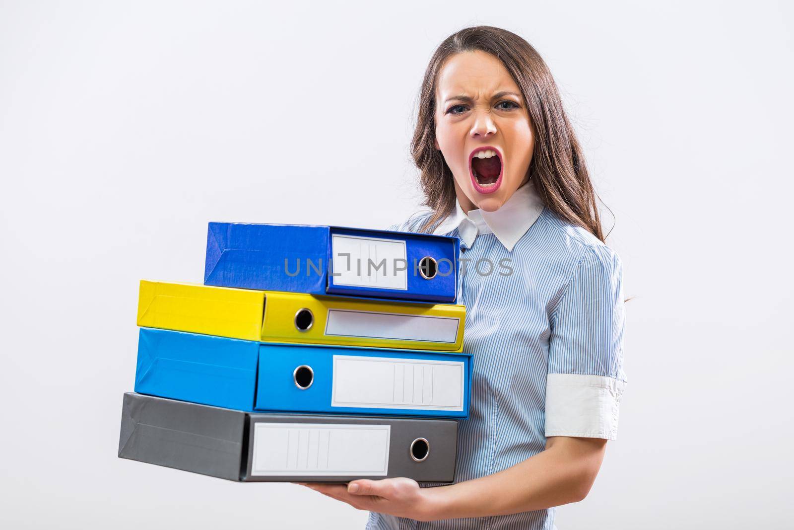 Image of furious businesswoman holding office archives on gray background.