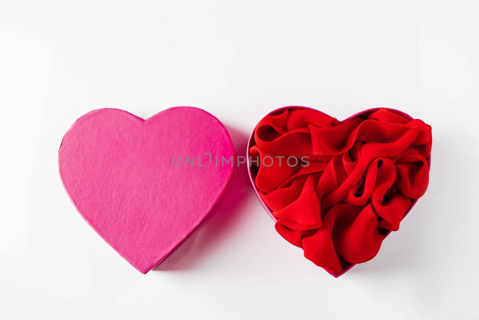 Heart shaped open gift box on white background. Concept for Valentine's Day. Open empty pink heart shaped gift box on a white background.