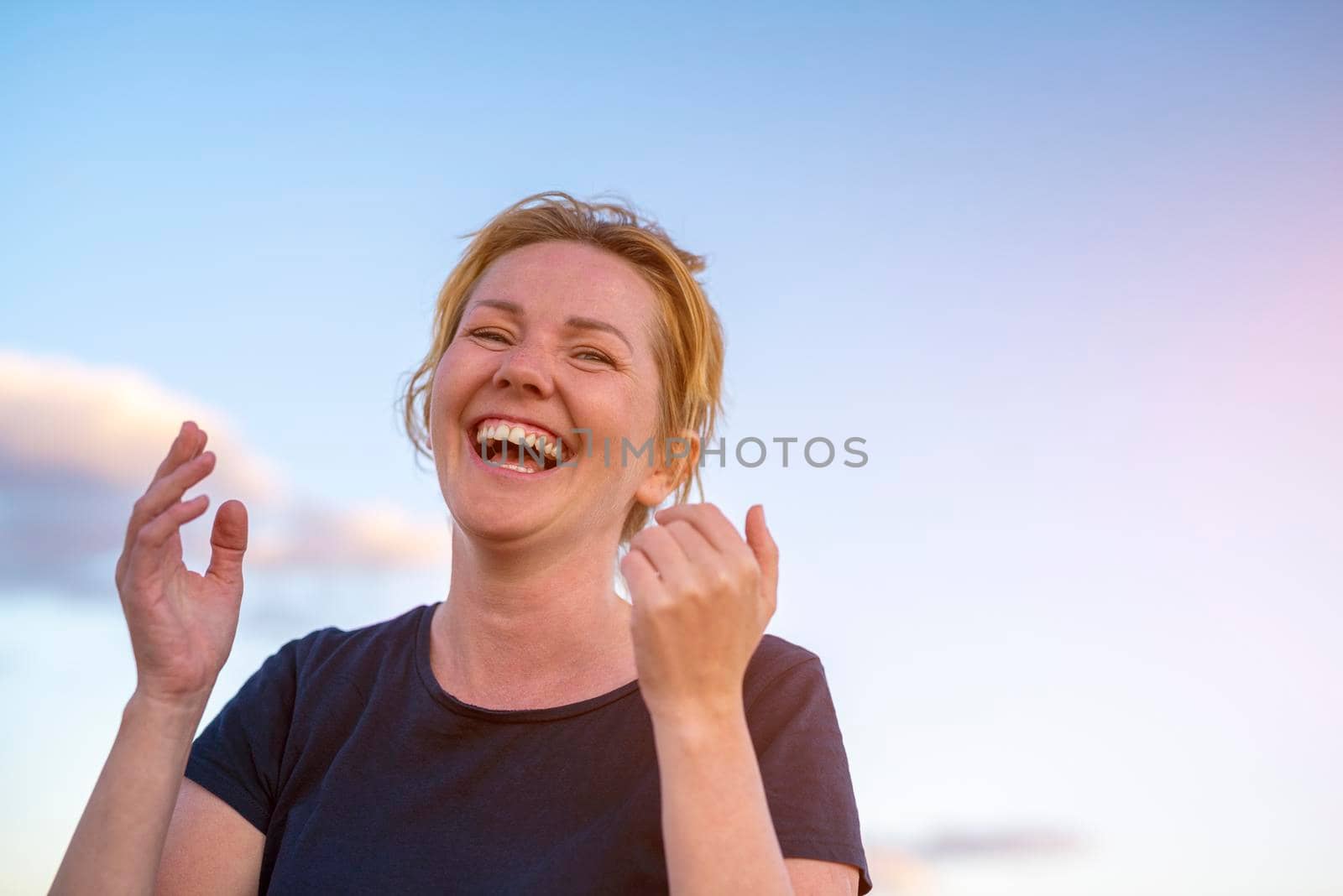 Young attractive white caucasian woman smiling and laughing on the beach warm summer evening by Alexxoma