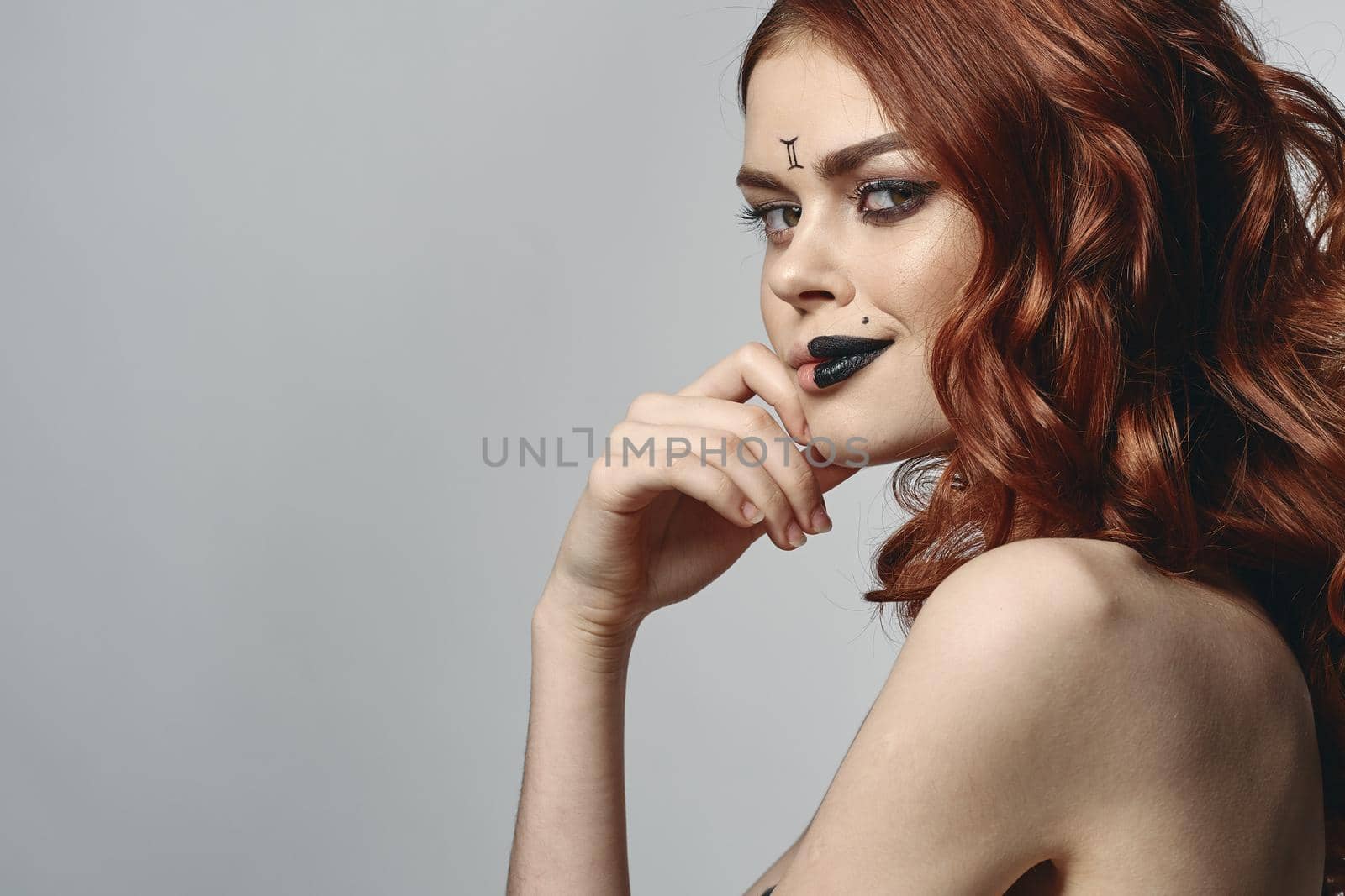 red-haired woman with bare shoulders bright makeup base zodiac sign horoscope. High quality photo