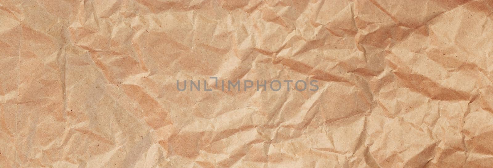Background of crumpled craft paper for packaging. Banner format.