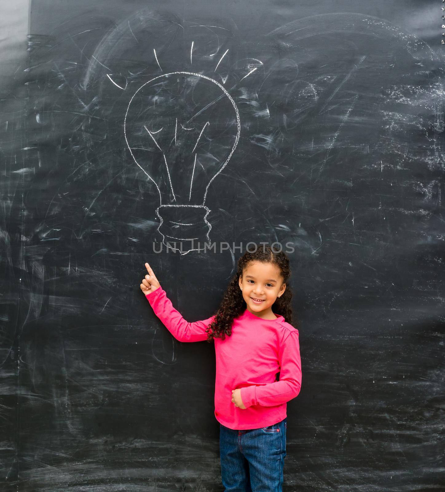 smiling little girl pointing at drawn on the blackboard lamp by GekaSkr