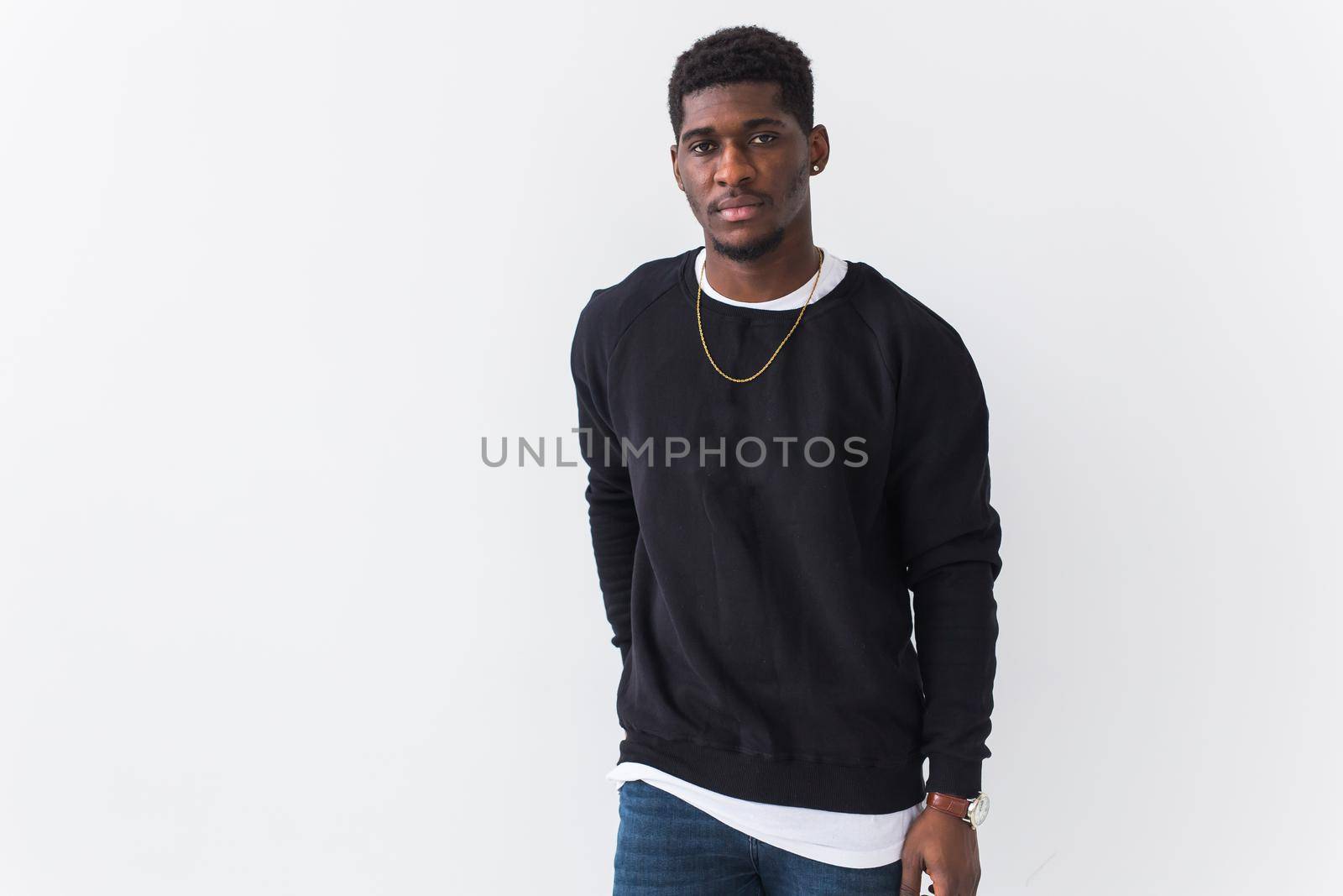 Portrait handsome young black man dressed in jeans and hoodie on white background. Street fashion and modern youth culture