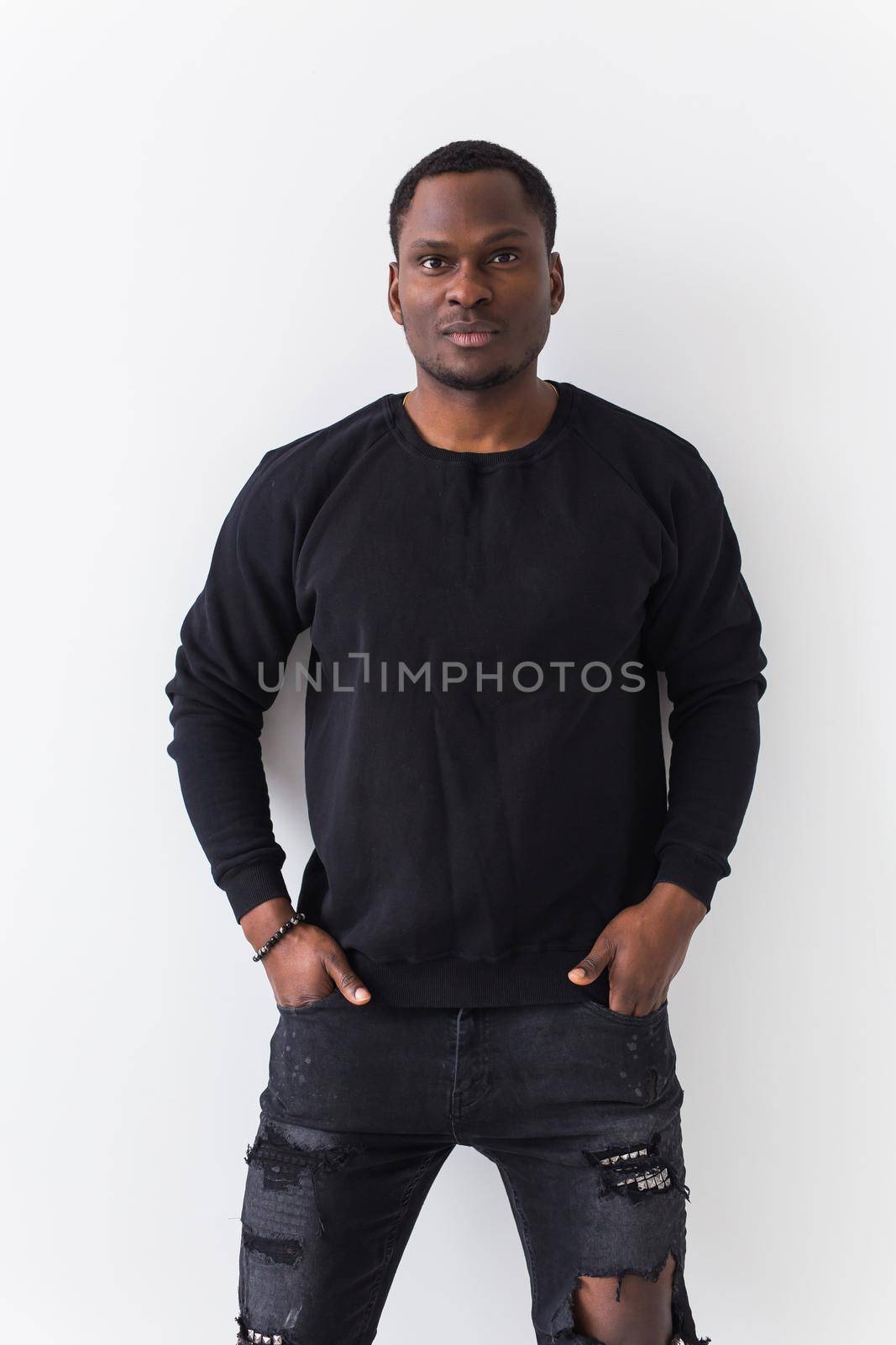 Youth street fashion concept - Portrait of confident sexy black man in stylish sweatshirt on white background. by Satura86