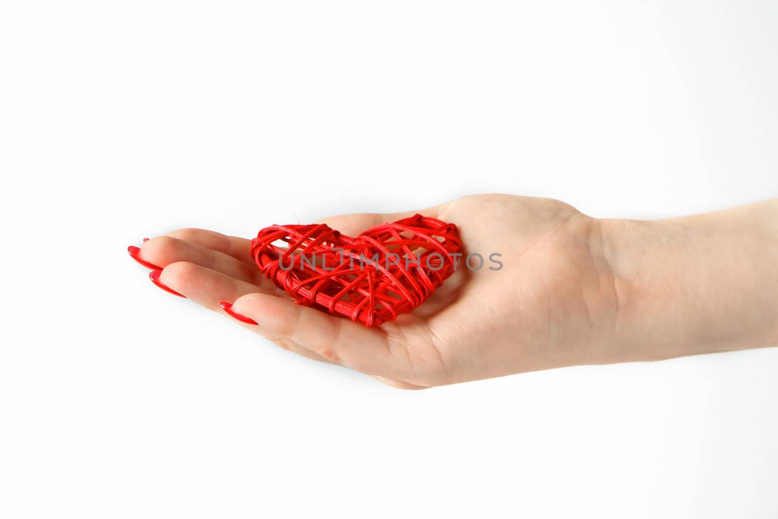 Red heart in the palm on a white background. Little red heart in the palm of a young woman.