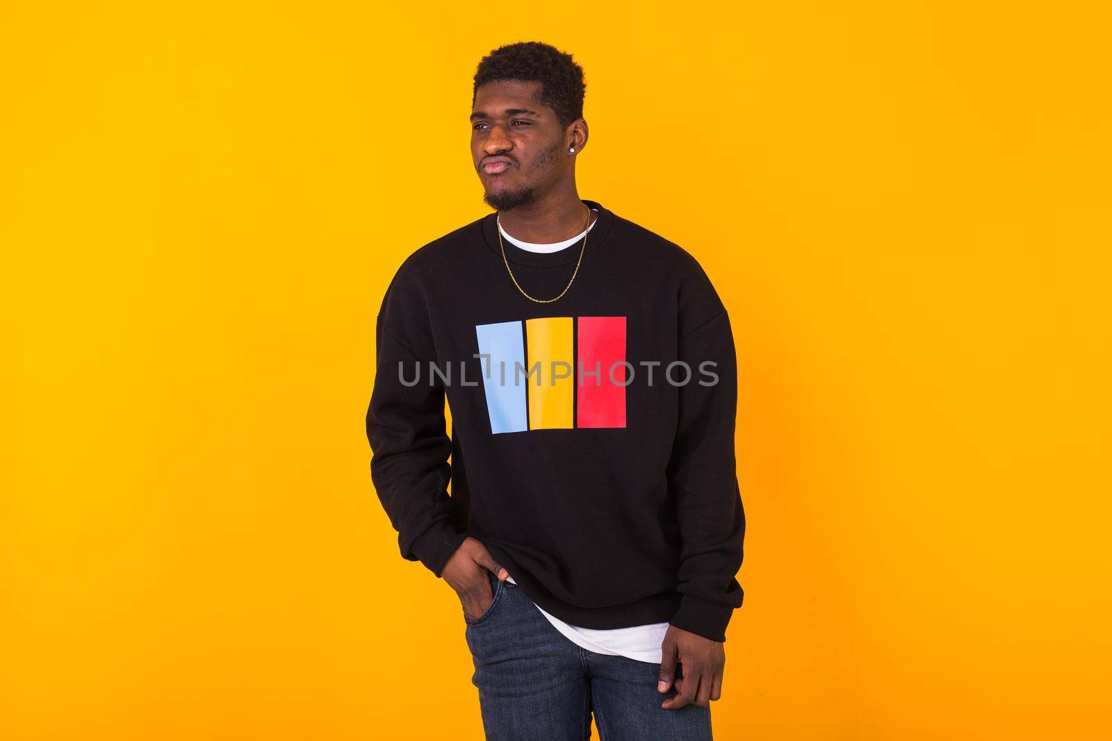 Handsome African American man posing in black hoodie on a white background. Youth street fashion photo with afro hairstyle