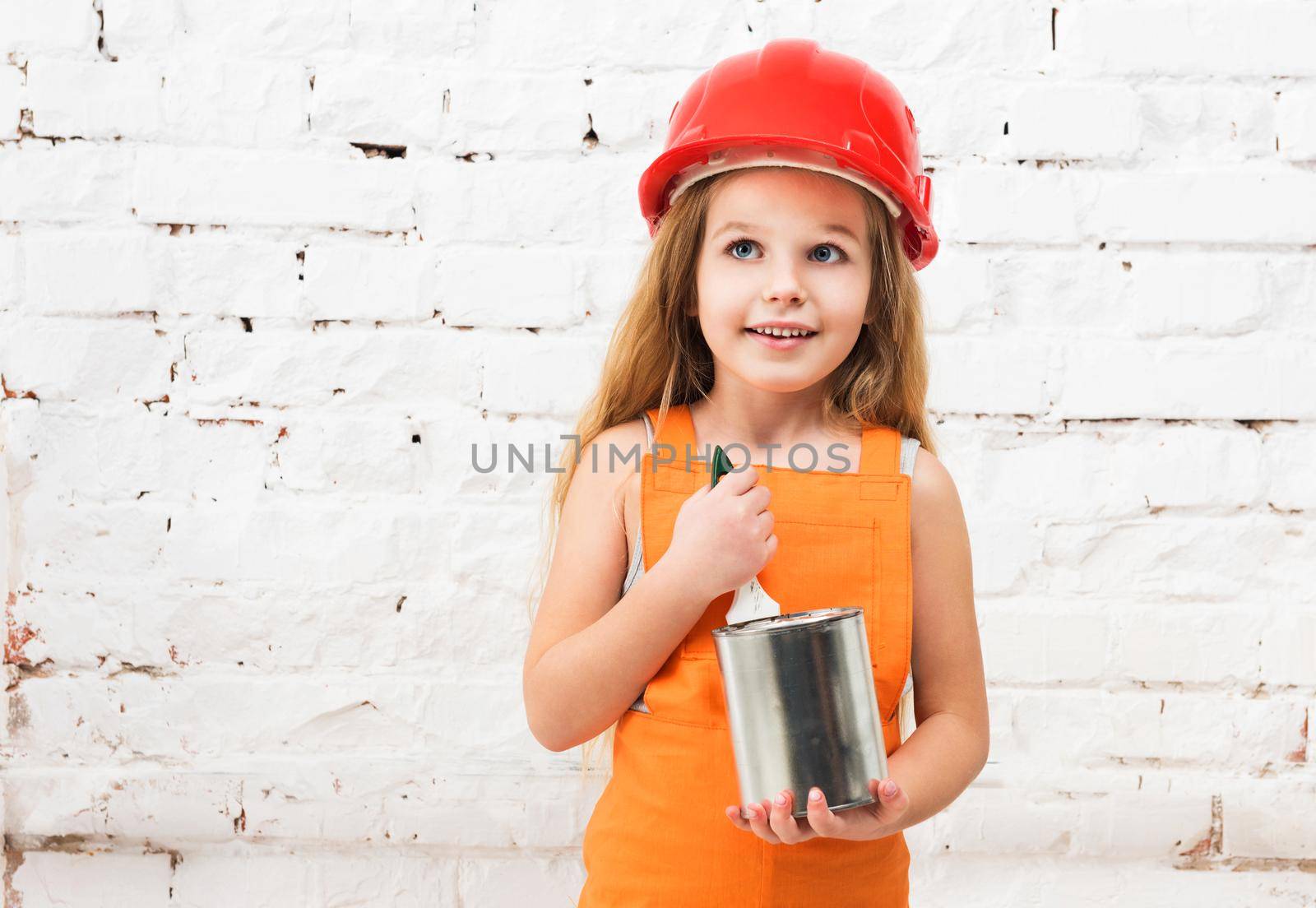 cute little girl in orange repairman uniform with paint tin in hands
