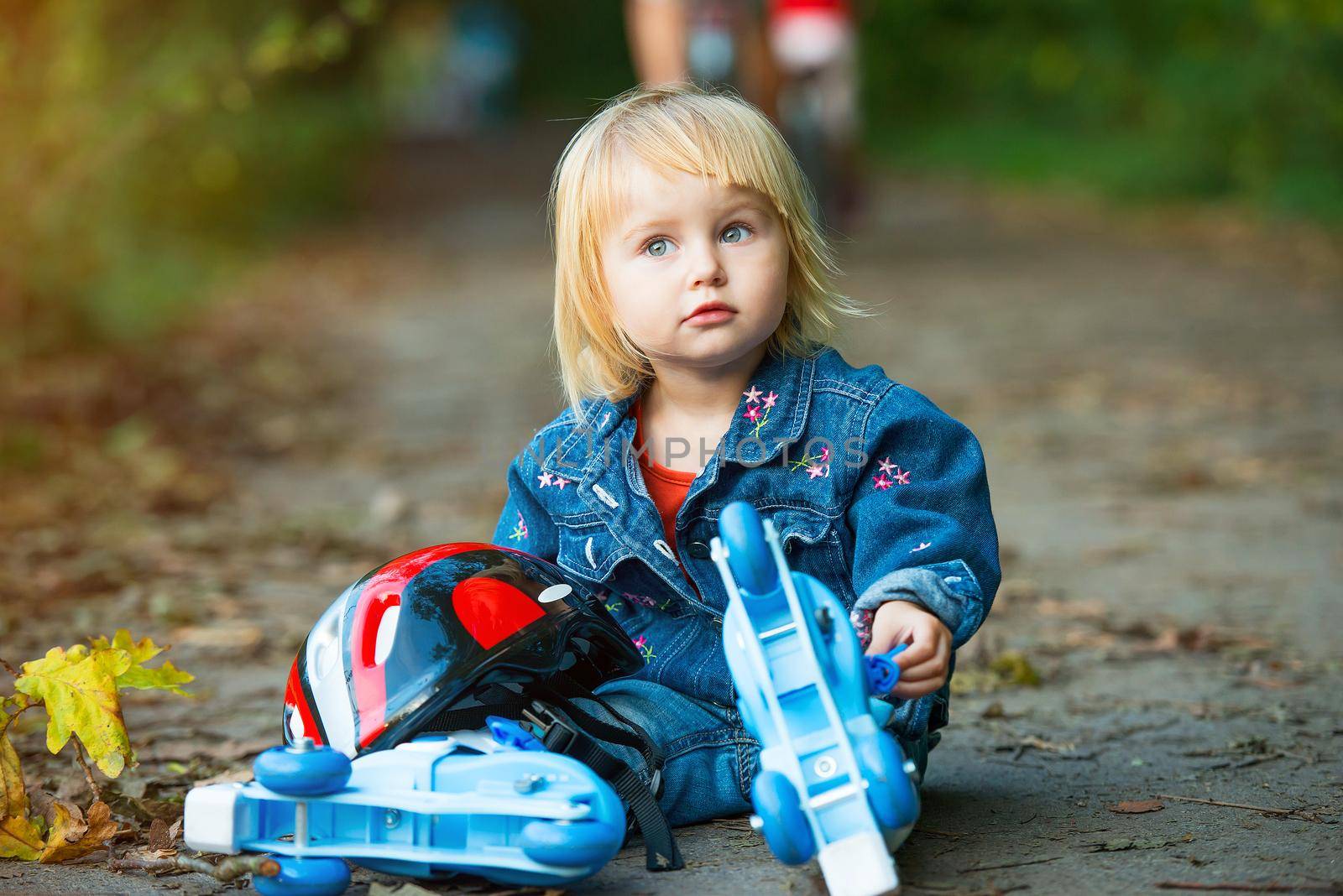 little girl on roller skates with helmet in the park