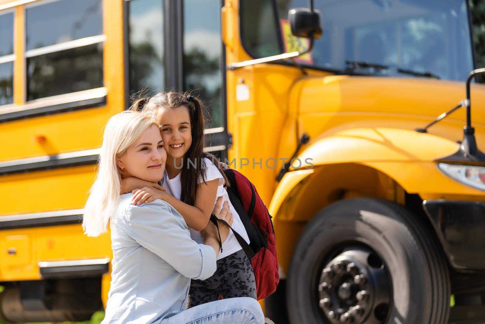 Mother brings her daughter to school near the school bus. back to school by Andelov13