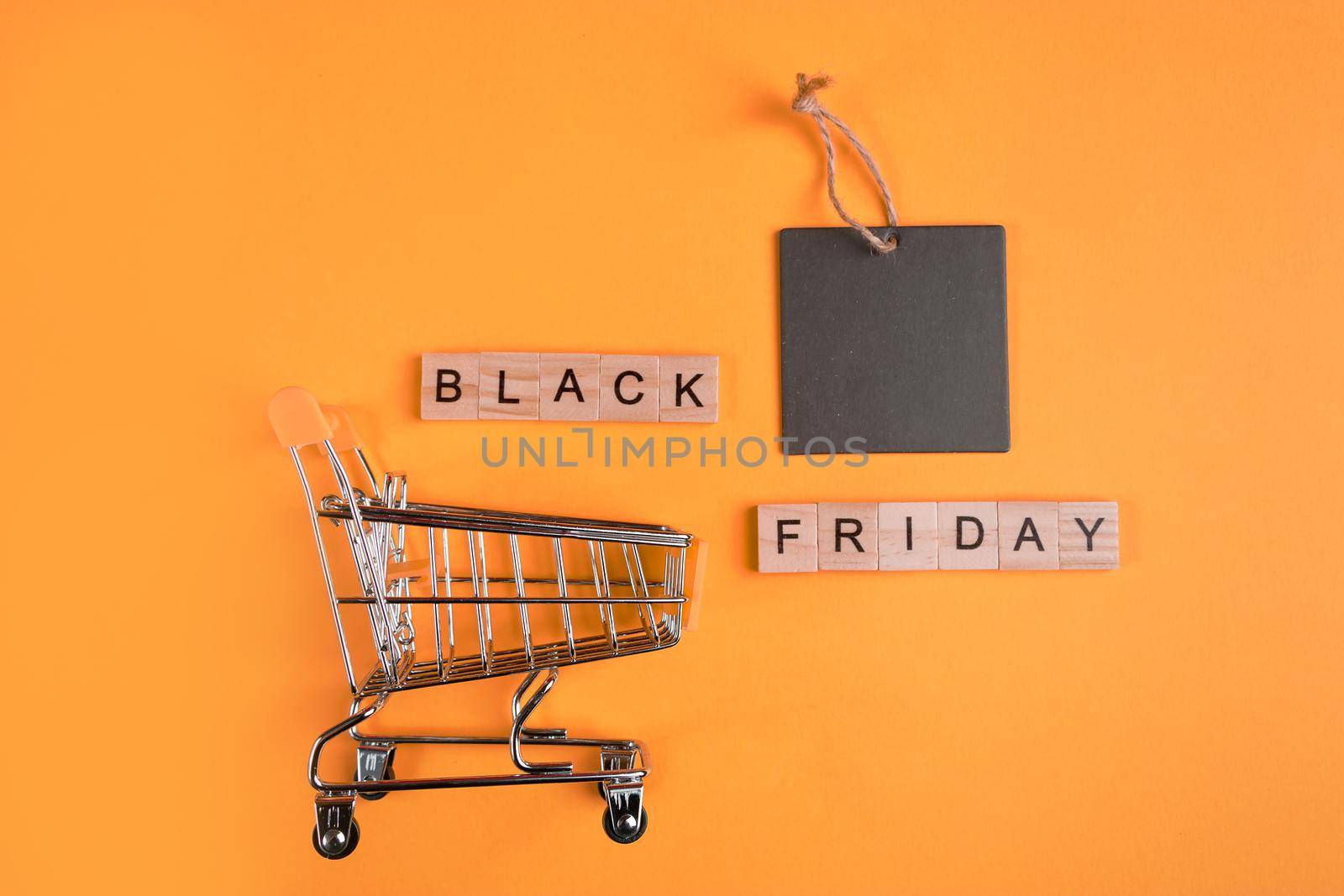 Sale and Black Friday concept. Mini shopping cart on a yellow background.