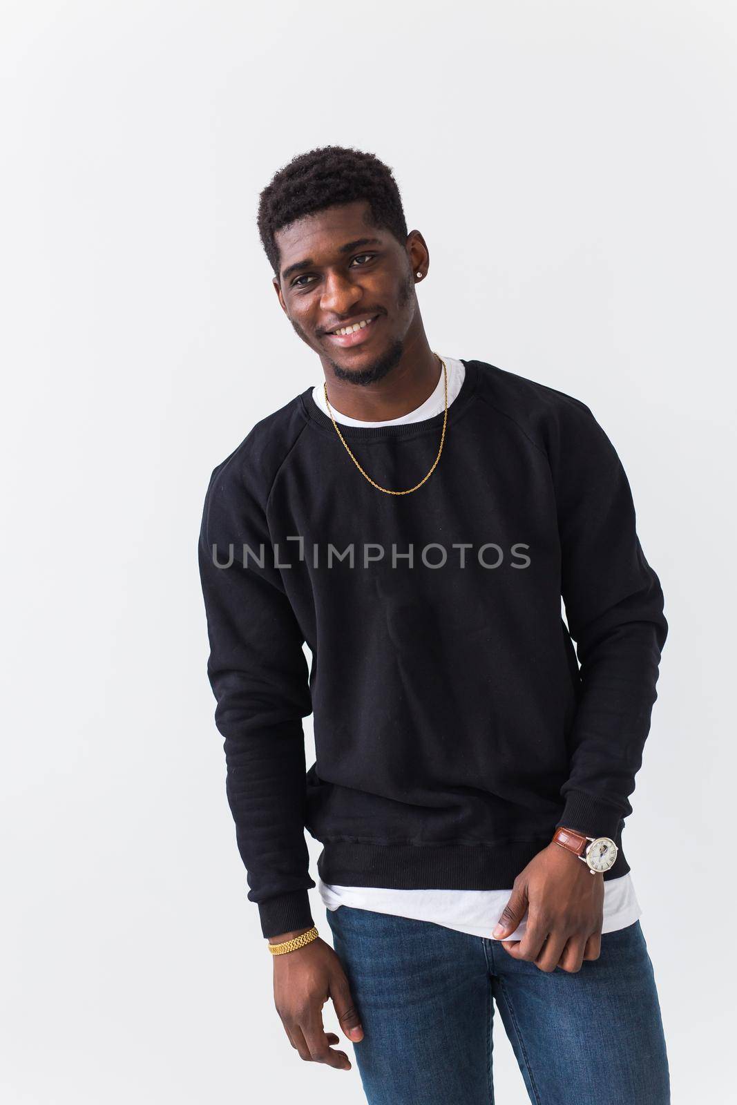 Handsome African American man posing in black sweatshirt on a white background. Youth street fashion photo with afro hairstyle. by Satura86