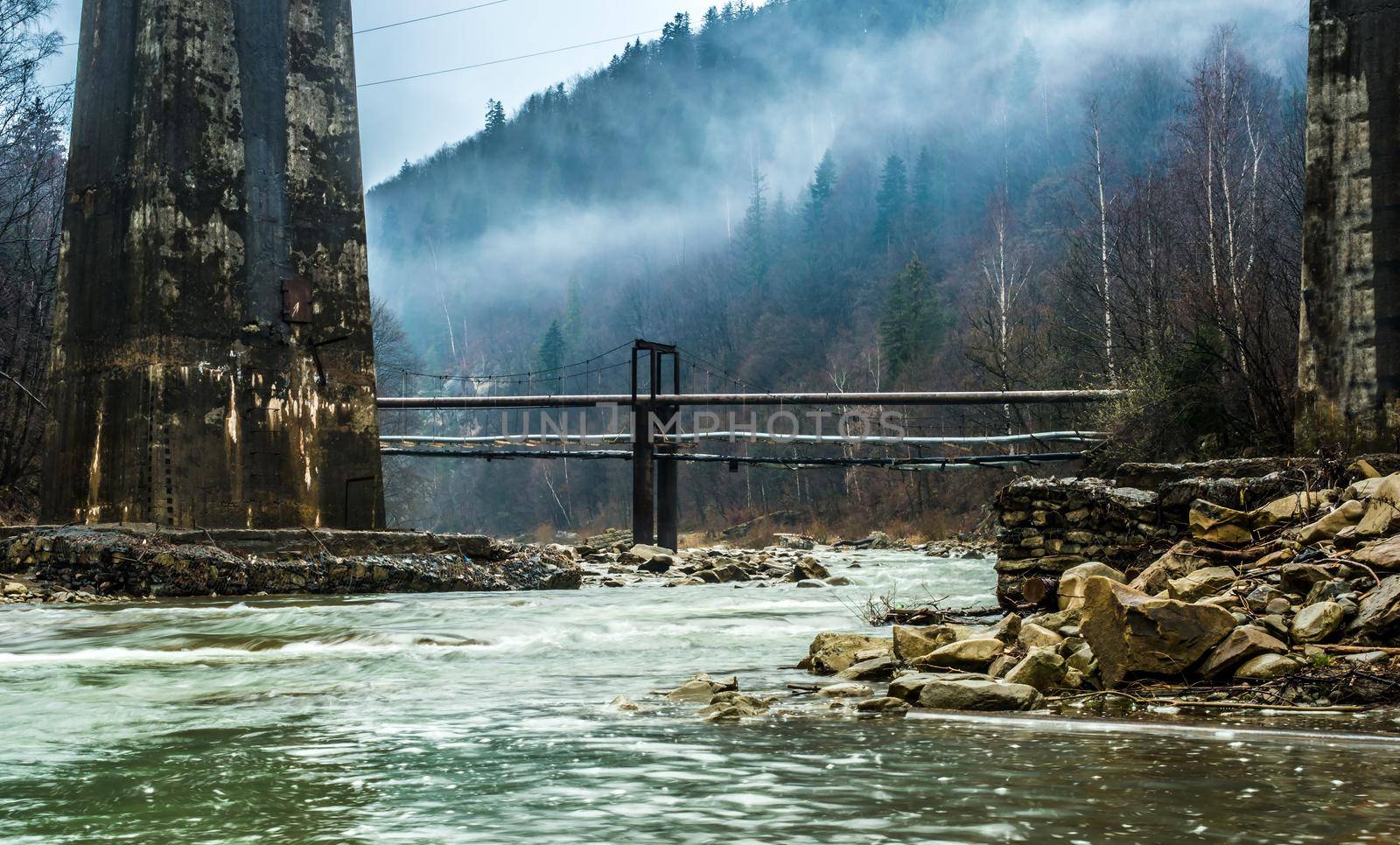 beautiful mountain landscape with lake and bridges in fog in Ukrainian Carpathians