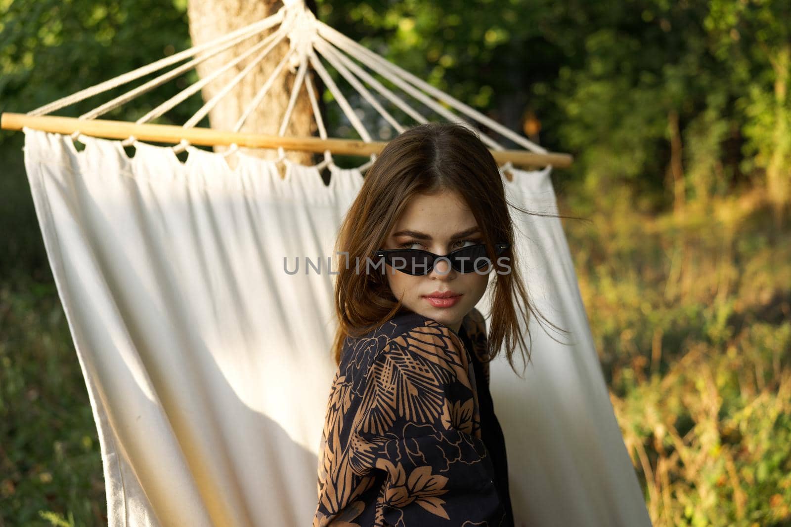 woman in sunglasses lies in a hammock outdoors summer lifestyle. High quality photo