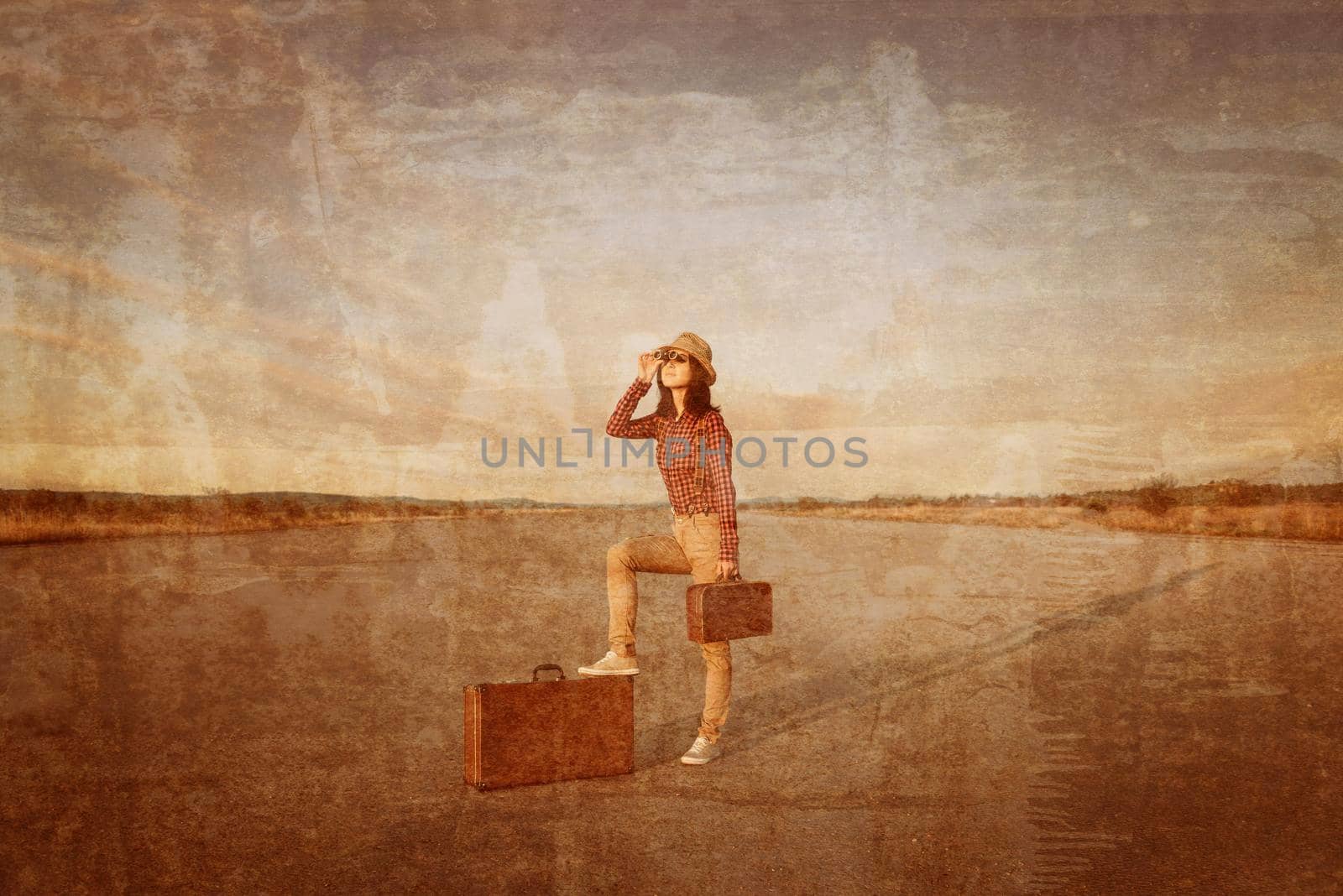 Young traveler hipster woman with retro suitcase looks through binoculars on road. Vintage image