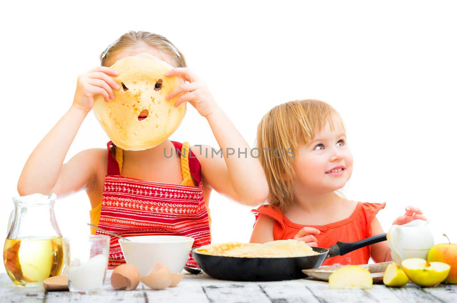 funny sisters cooking pancakes on kitchen isolated on a white background