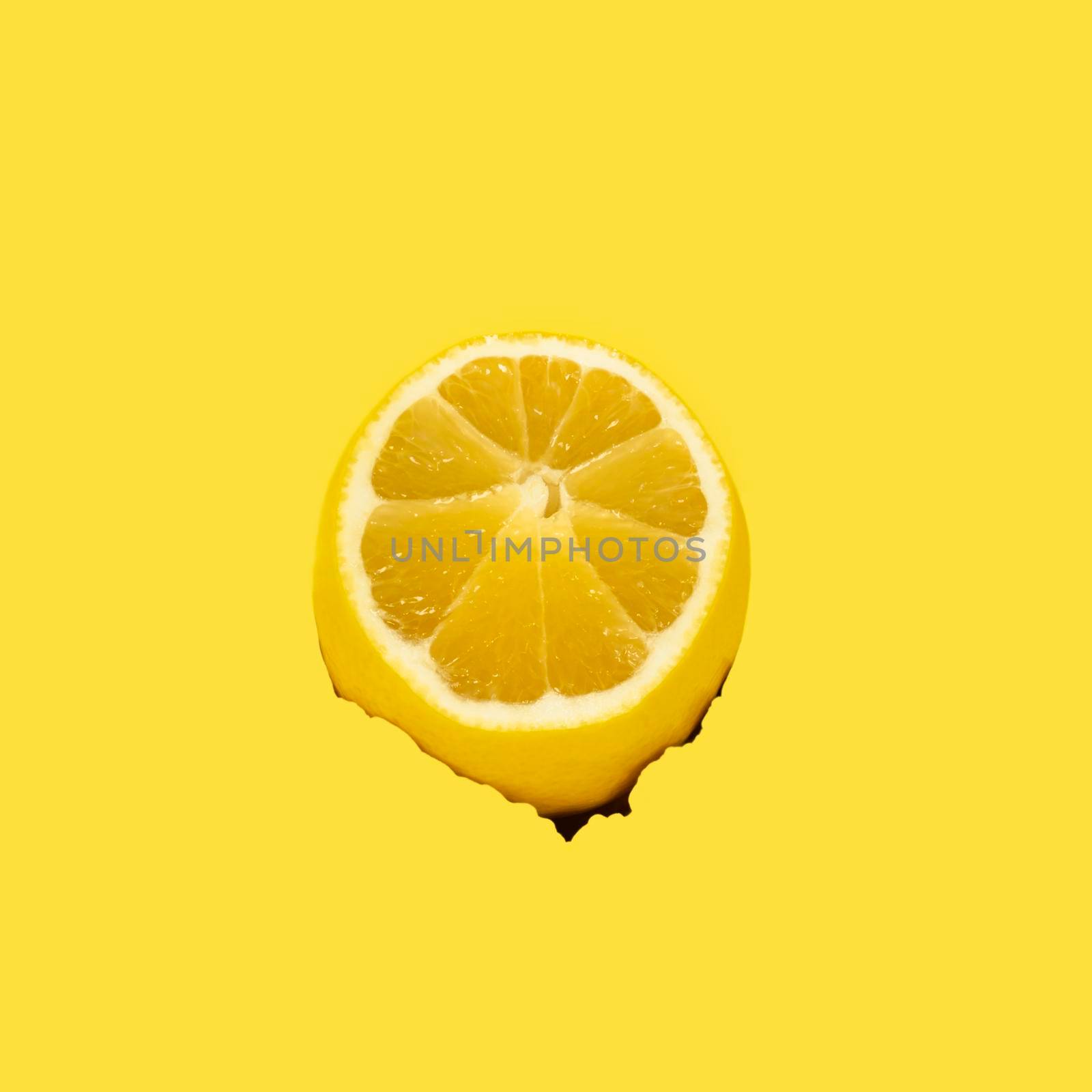 Torn hole on a yellow background and lemon as a source of vitamin C and prevention of colds and viral diseases.