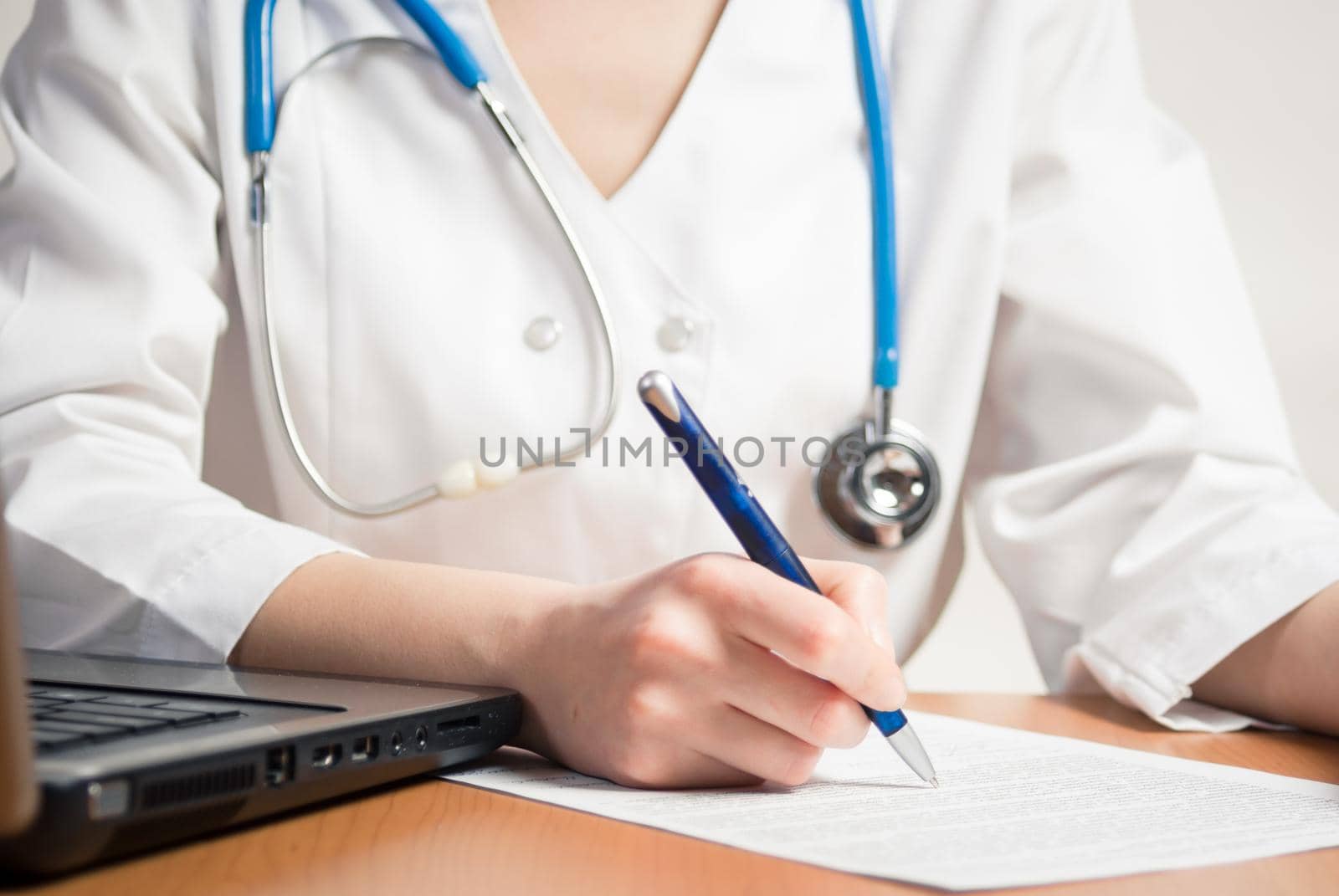 Doctor writes at table in worksheet