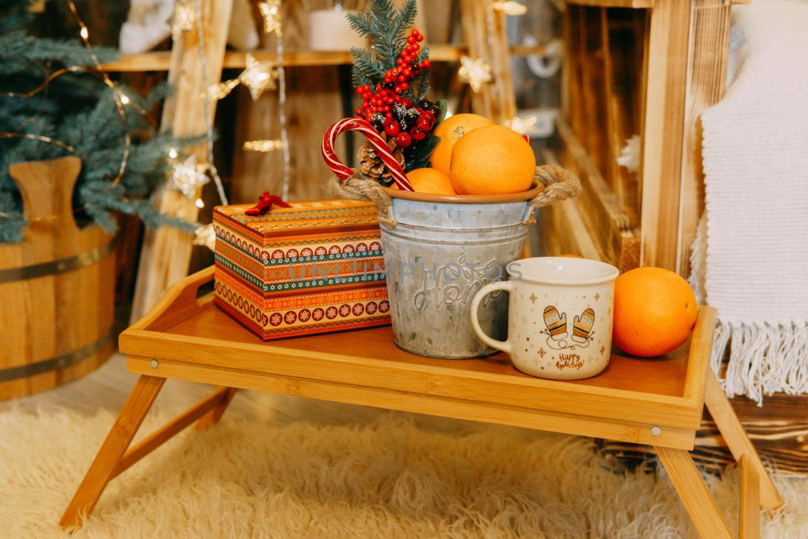 Tangerines, a gift box and Christmas decorations, lollipops on the table. The concept of a New Year's home decor.