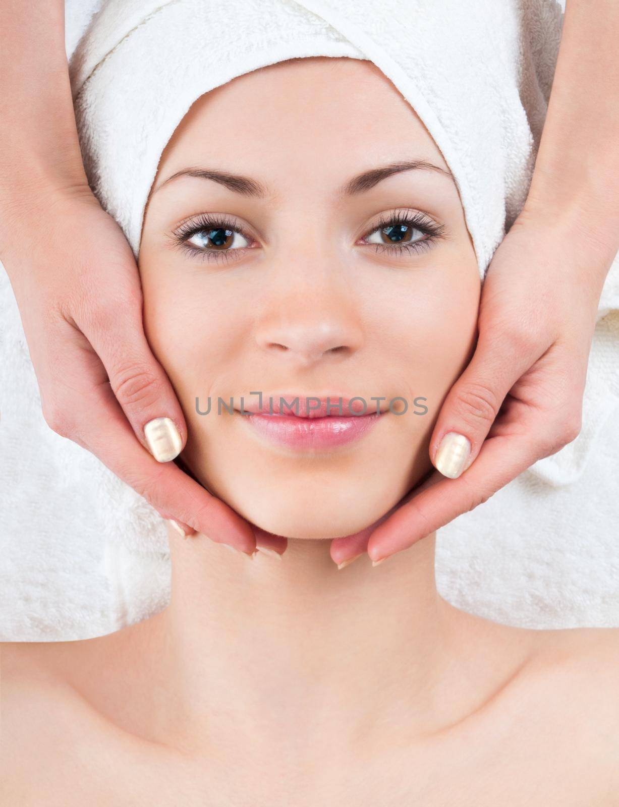 young woman enjoying facial massage in spa by GekaSkr