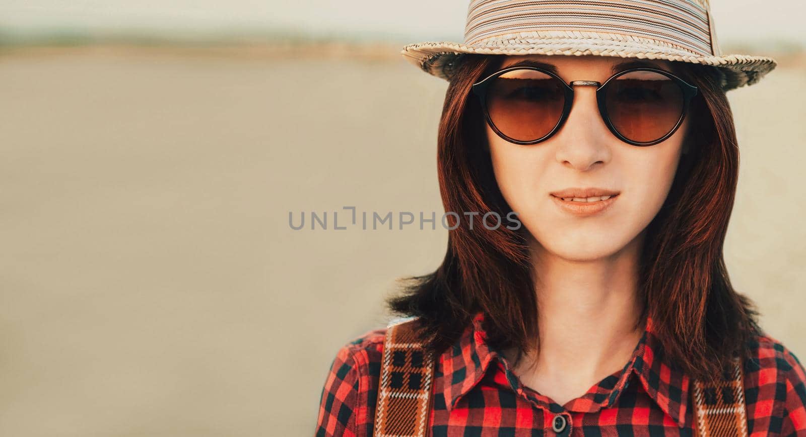 Portrait of traveler beautiful young woman in sunglasses and hat outdoor. Space for text in left part of image