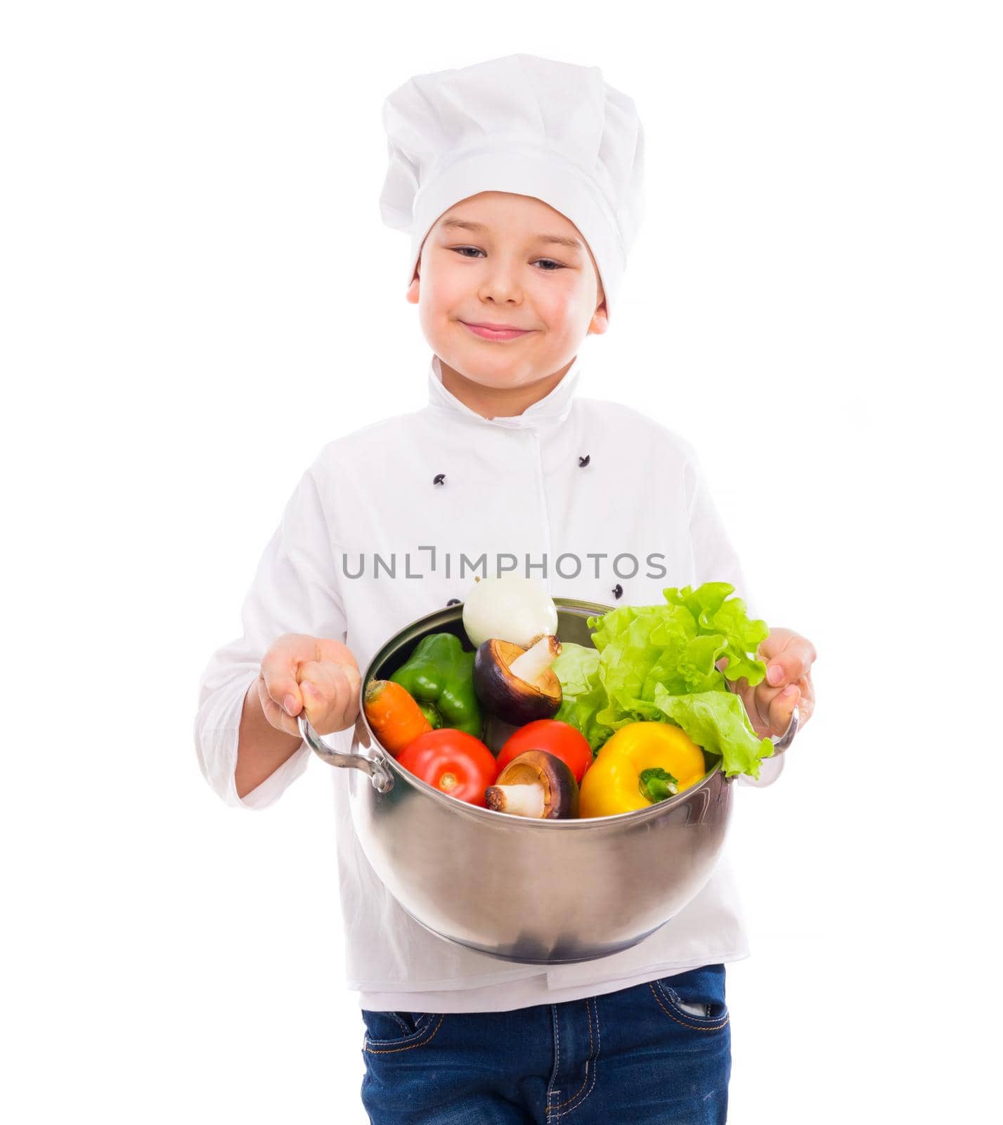 funny little boy-cook in uniform holding bowl with vegetables in hands isollated on white background