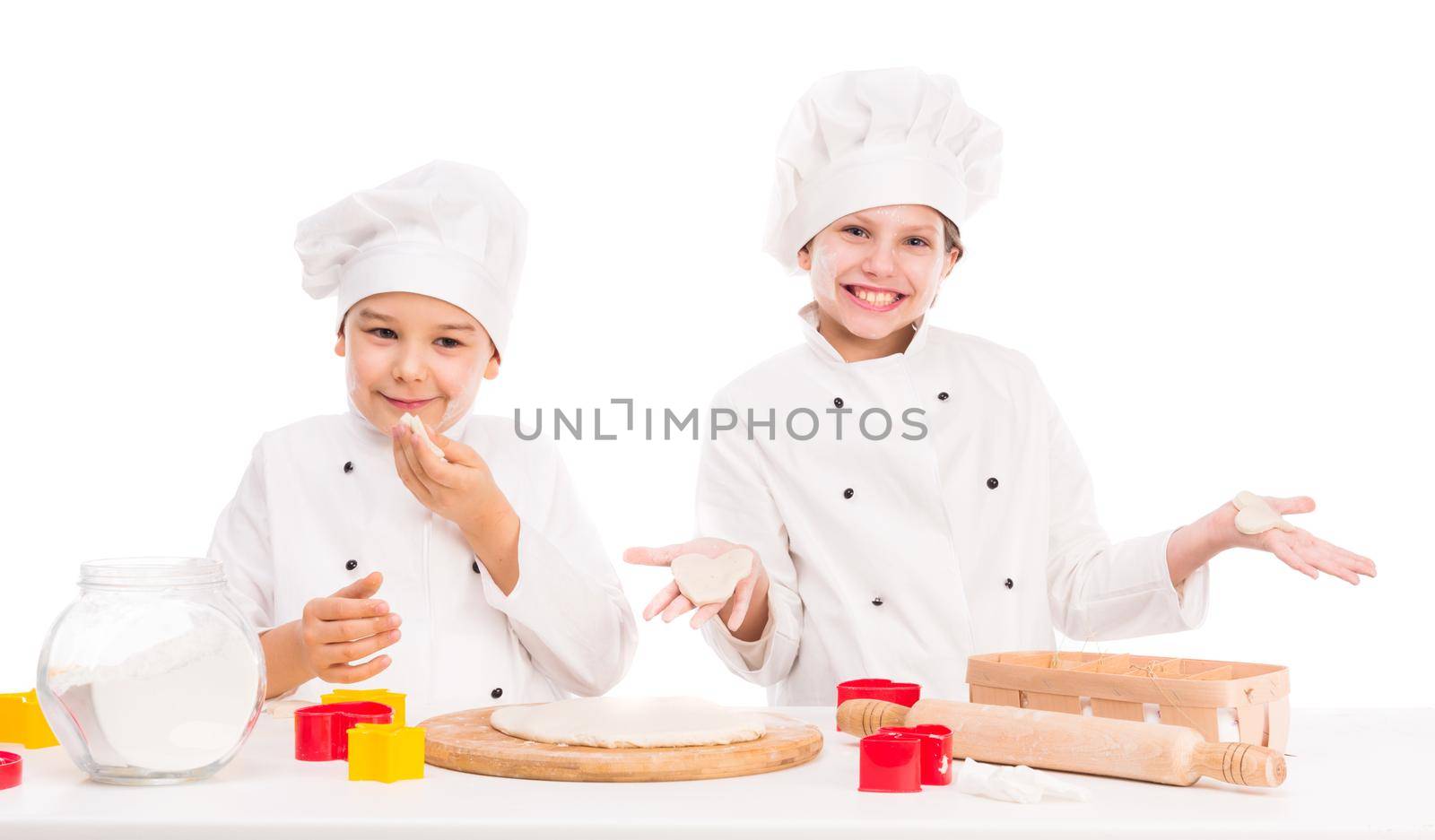 little boy and girl in white uniform kneating dough together