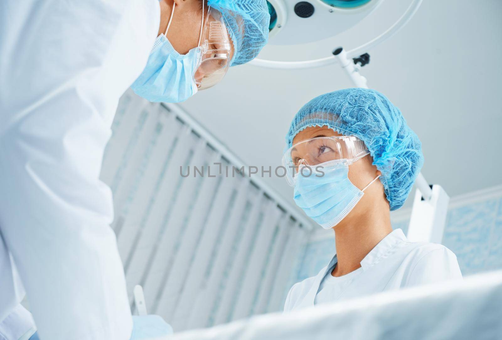 Surgeon and assistant in operating room by alexAleksei