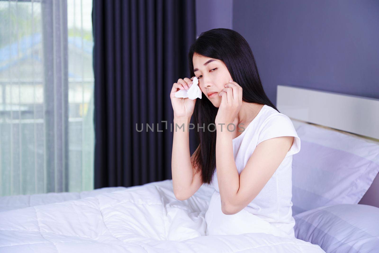 woman is crying on bed in the bedroom