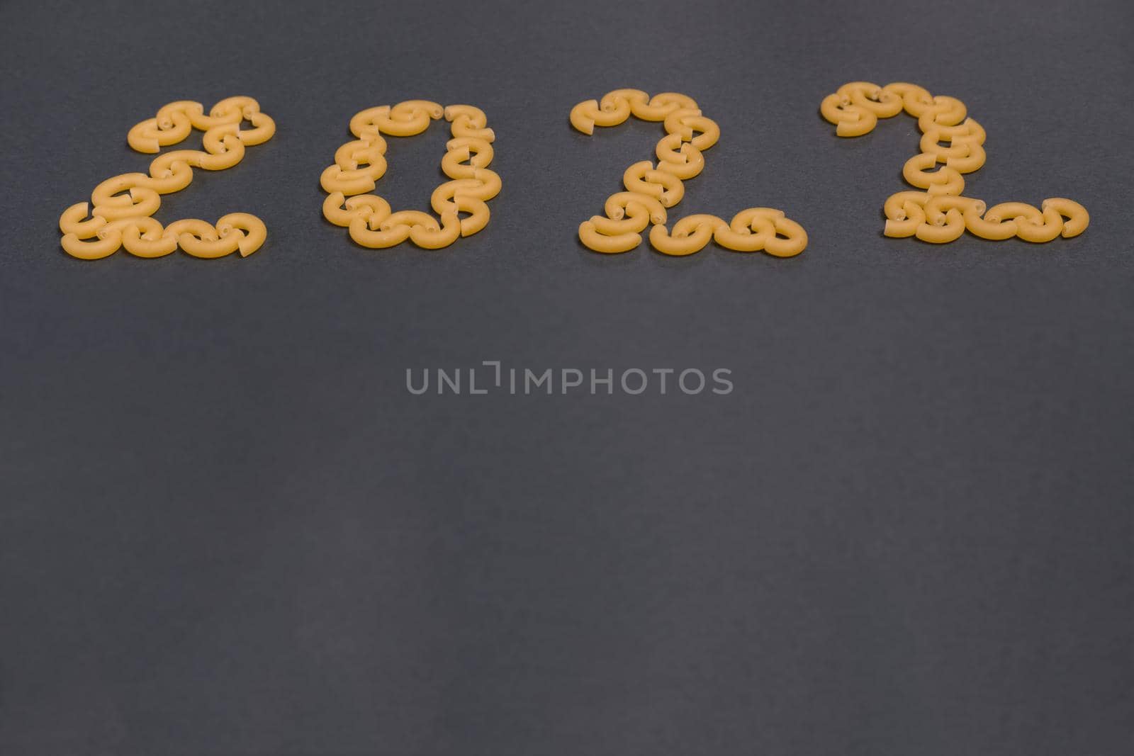 Number 2022 is laid out of pasta on black paper background. Flat lay. Concept photo by Ekaterina34