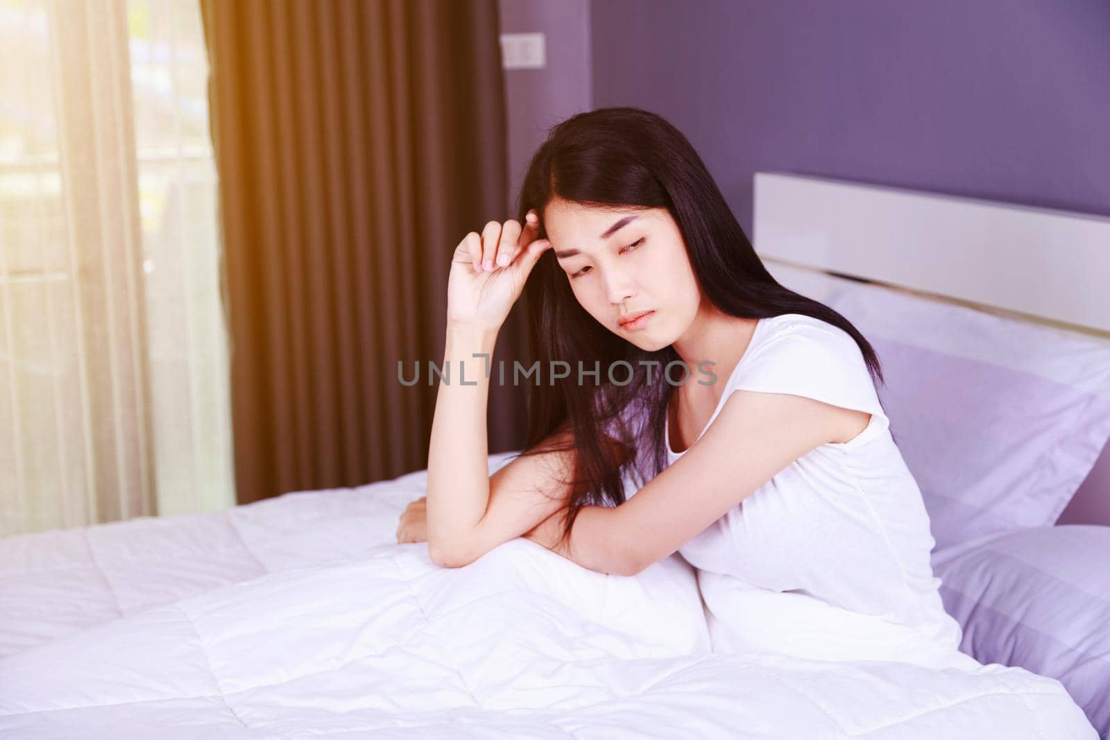 worried woman thinking on bed in the bedroom