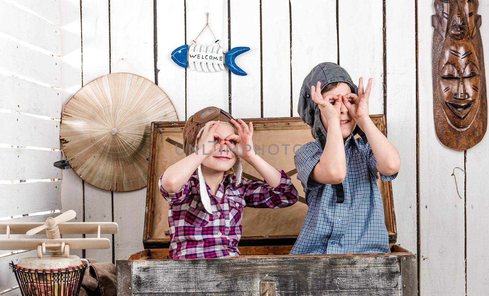 two little kids in pilot hats making glasses with hands by GekaSkr