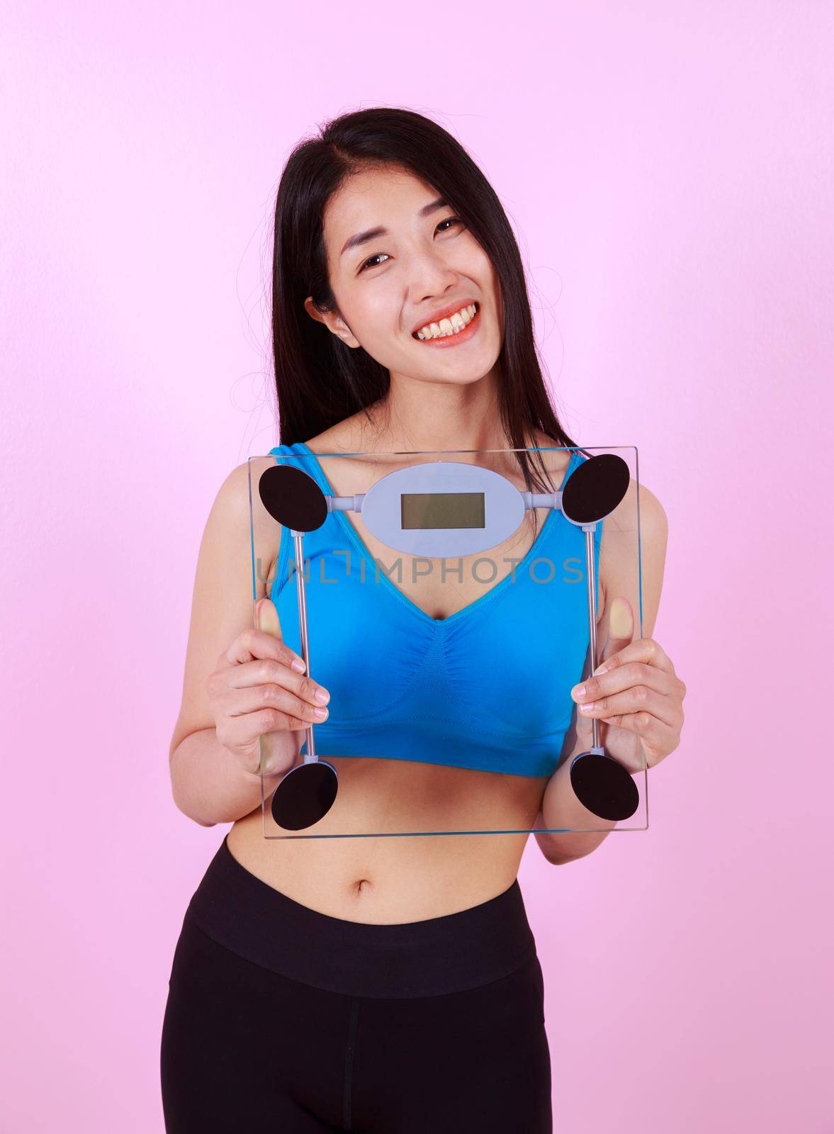 happy slim woman holding a weight scale