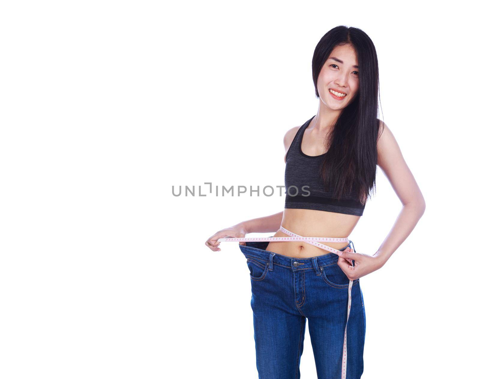 weight loss woman wearing her old jeans and measure tape isolated on a white background