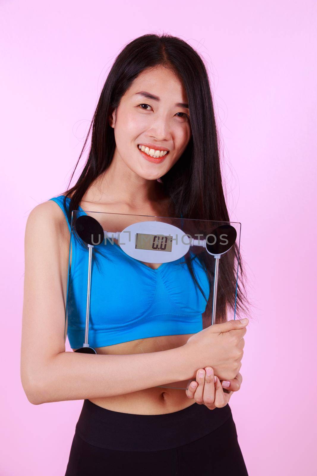 happy slim woman holding a weight scale