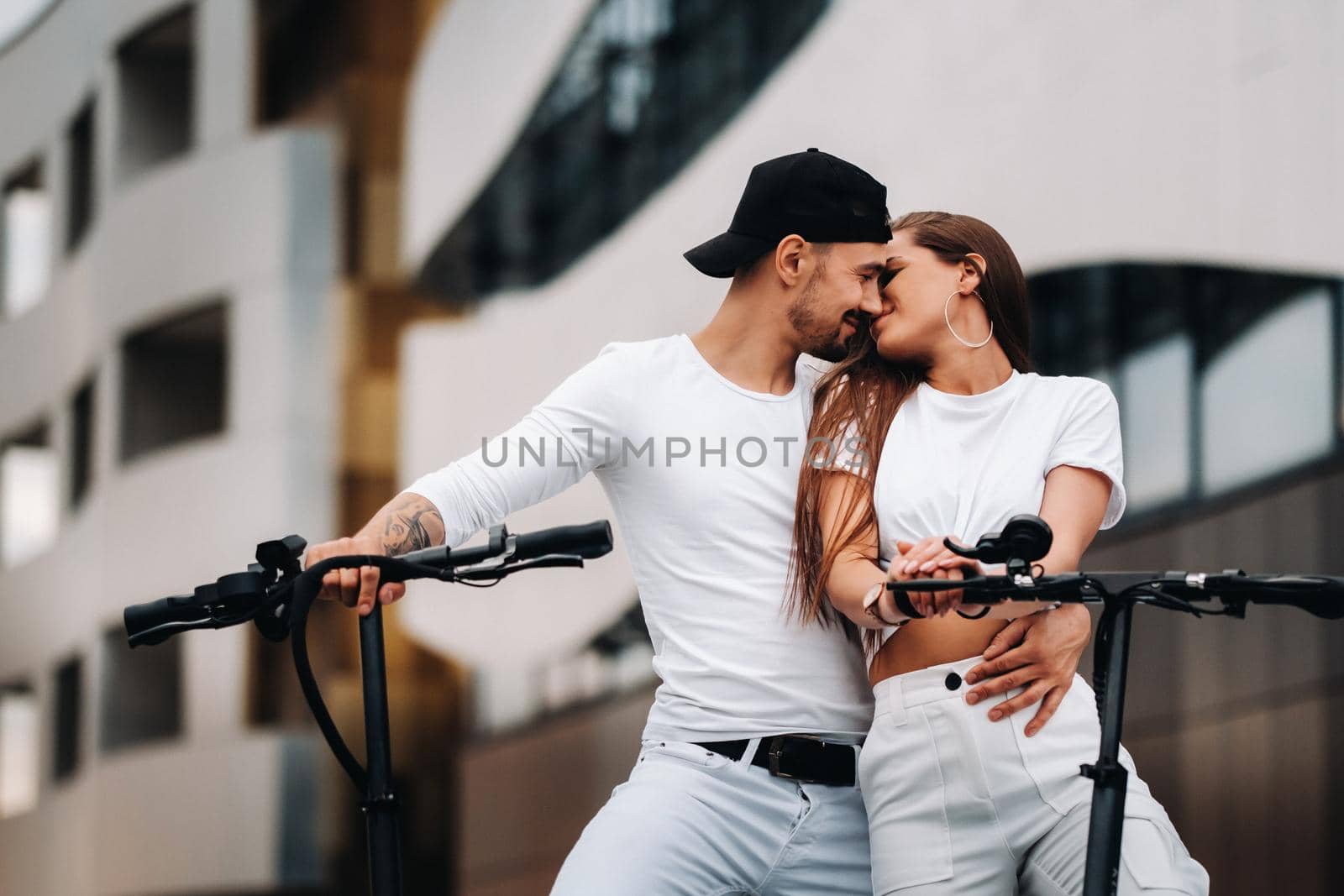 A girl and a guy are walking on electric scooters around the city, a couple in love on scooters. by Lobachad