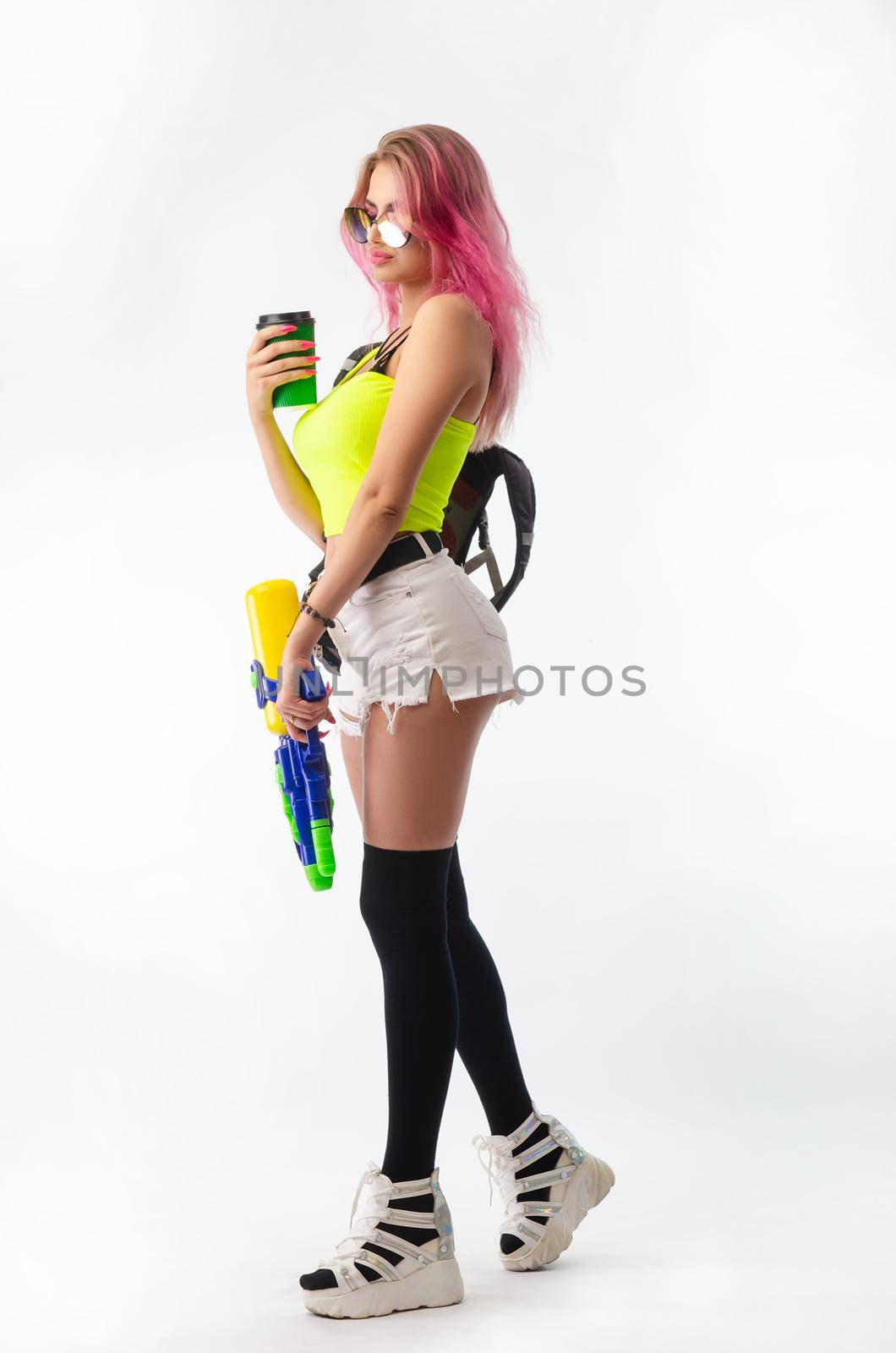 a girl with a water gun in summer clothes, slim and sexy, isolated on a white background drinking coffee