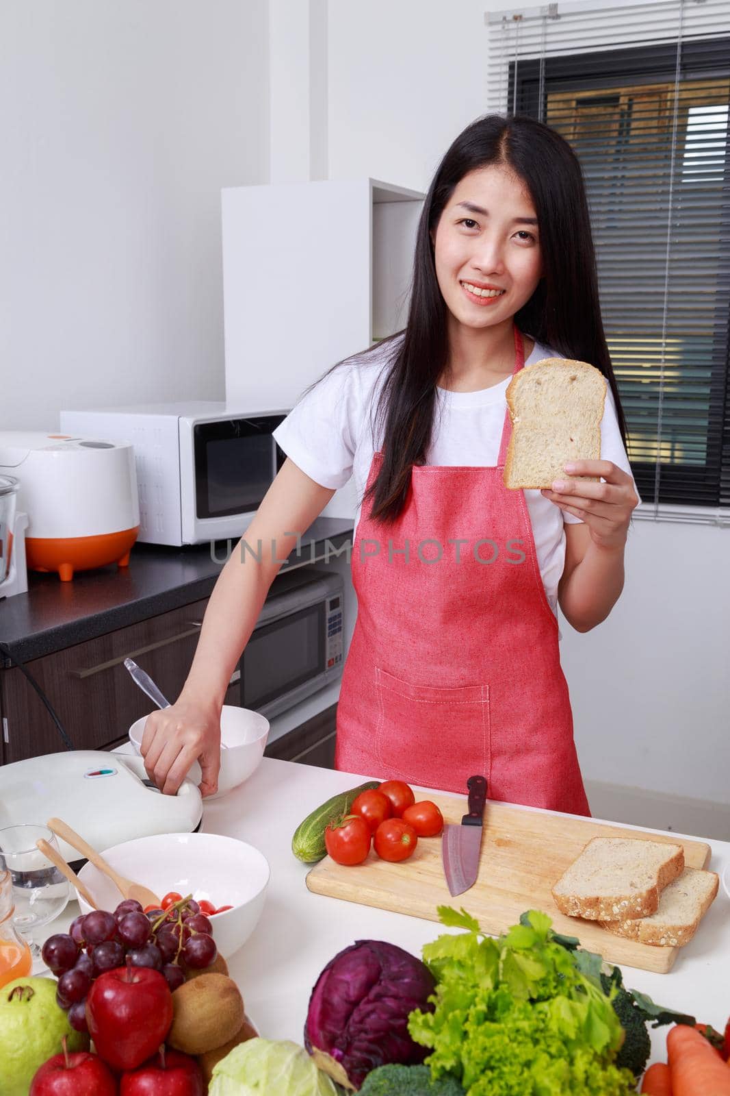 woman preparing bread to sandwich toaster in kitchen room at home