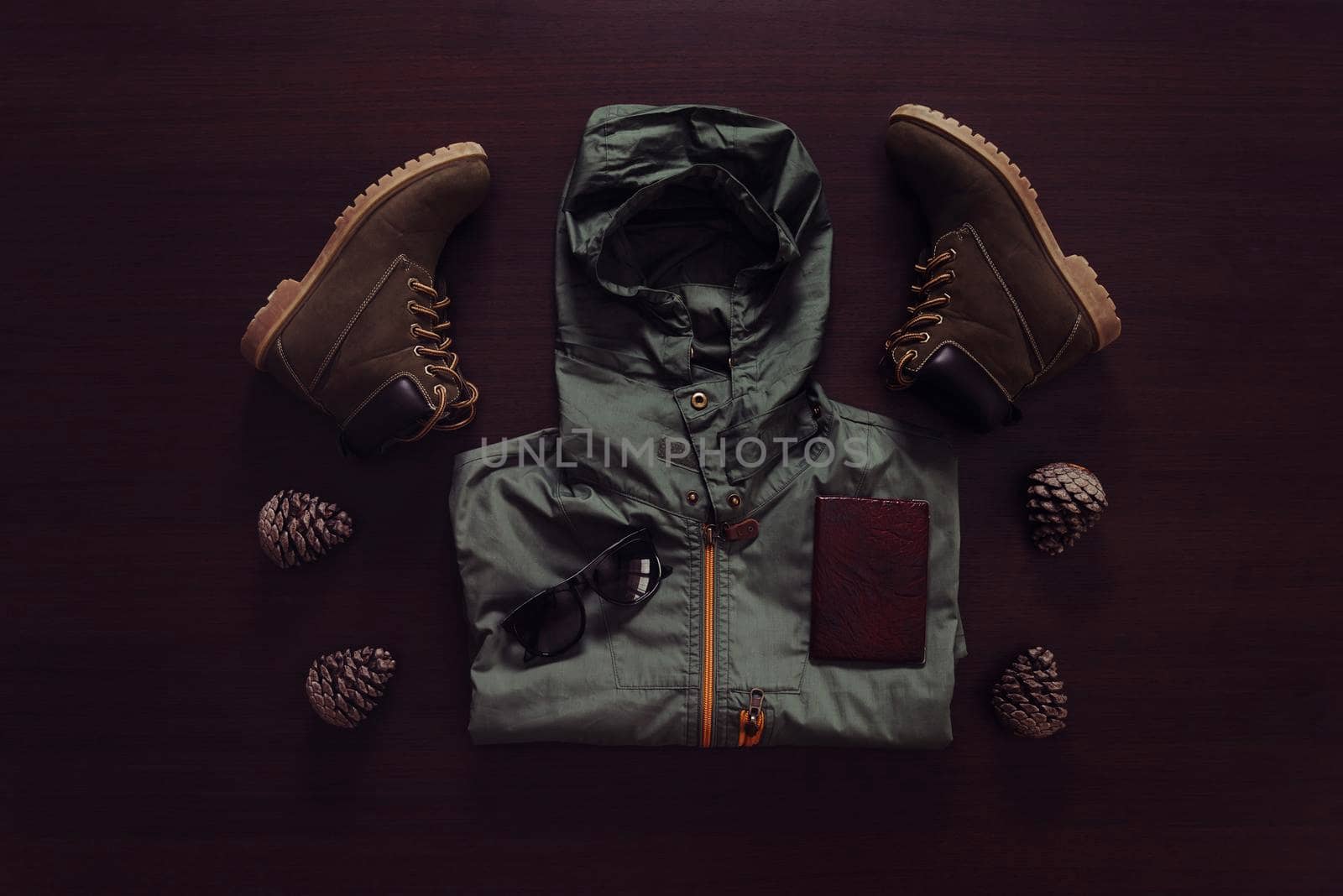 Set of clothing and accessories for traveler man on wooden background, top view