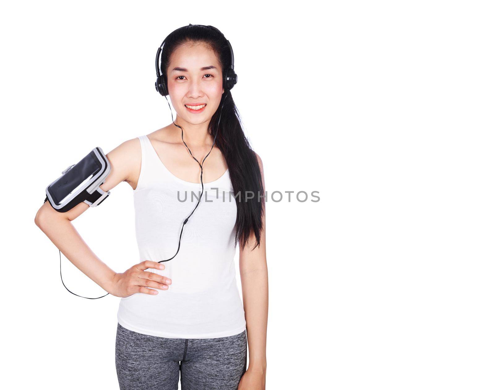 young smiling fitness woman listening to music with earphones isolated on a white background