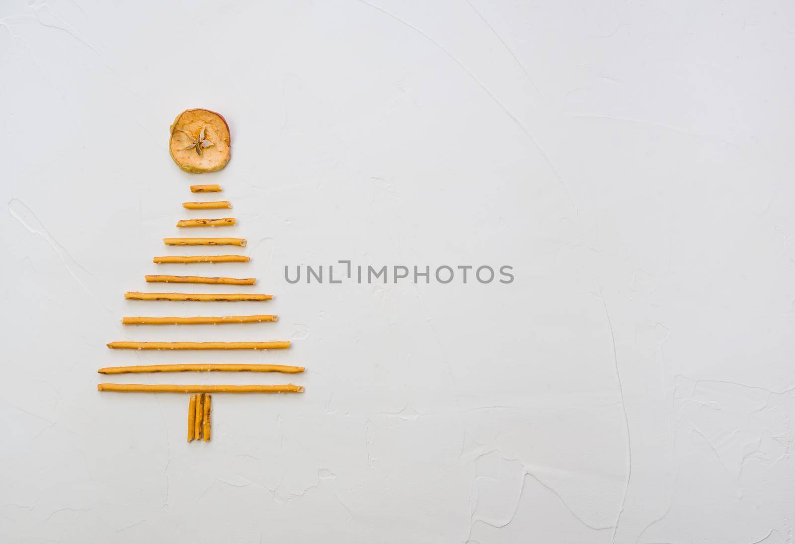 Christmas tree made from pepero straws cookies, on white background texture. Top view with space for text on the right by Ekaterina34