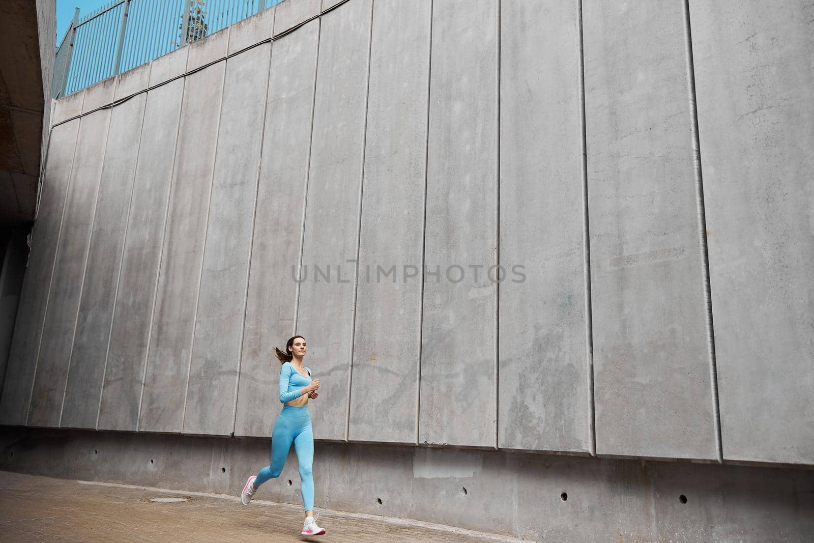 Beautiful fit young woman jogger is running outdoors by Yaroslav_astakhov