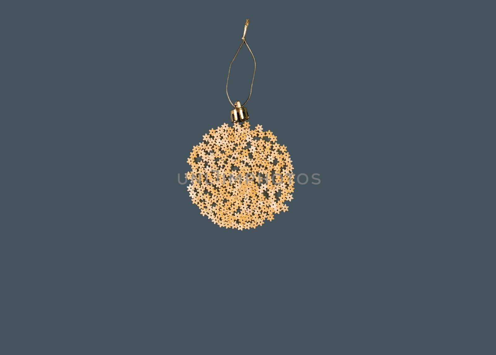 Christmas decoration on a tree in the form of a ball of pasta on a blue paper background, top view. Conceptual photo. by Ekaterina34