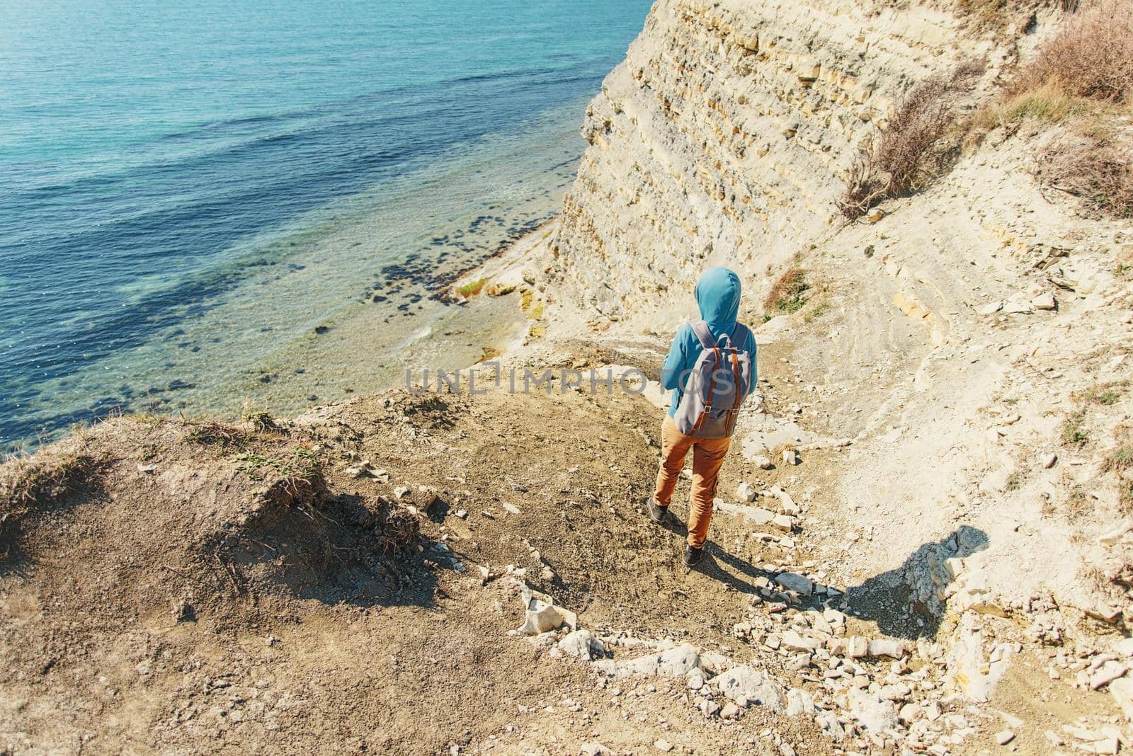 Traveler girl walking on coastline in summer by alexAleksei