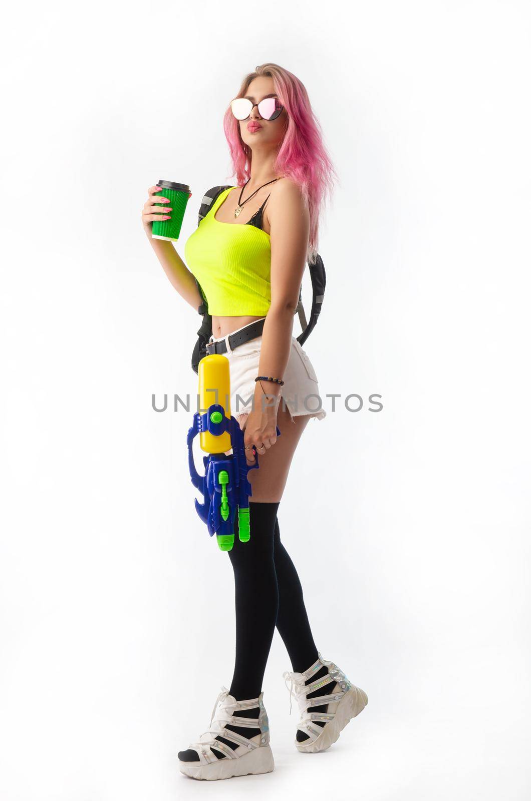 girl with a water gun in summer clothes, slim and sexy isolated on a white background by Rotozey