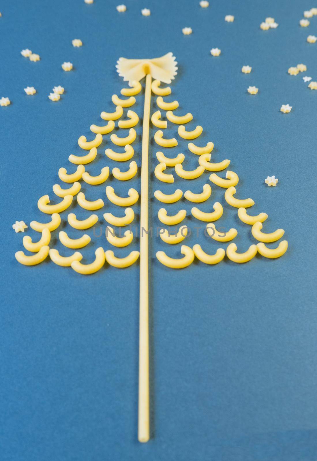 Christmas tree made from pasta, stars on a paper blue background. by Ekaterina34