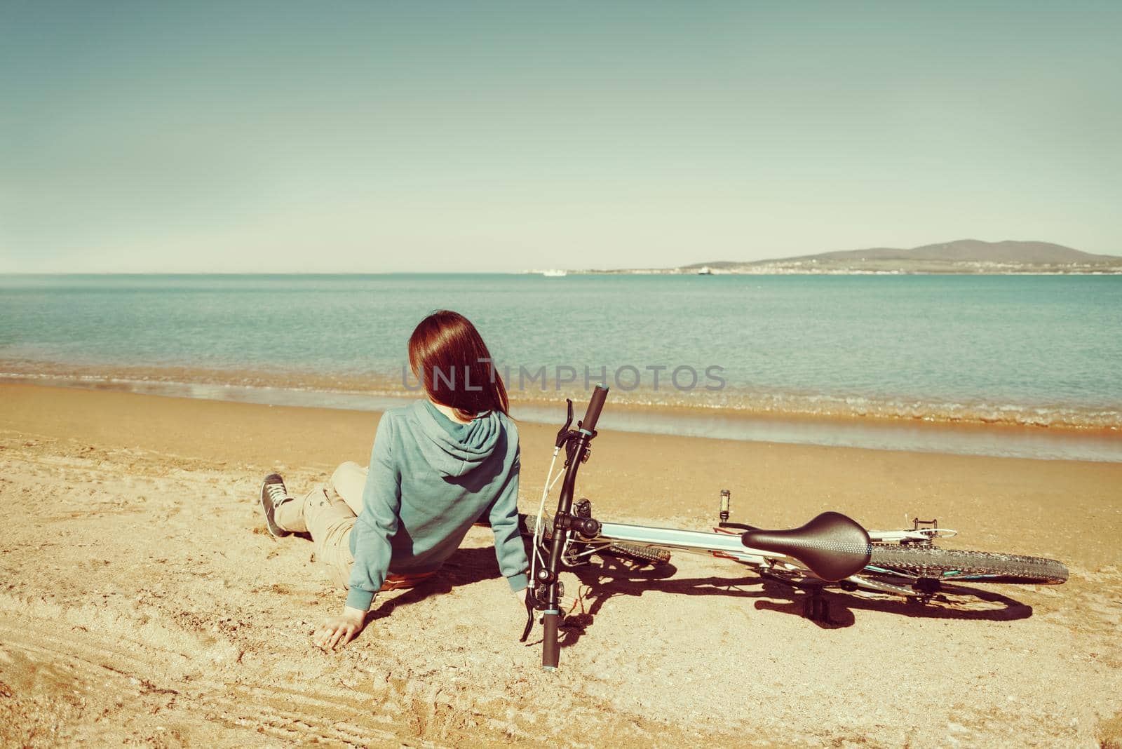 Girl resting on beach with a bicycle by alexAleksei