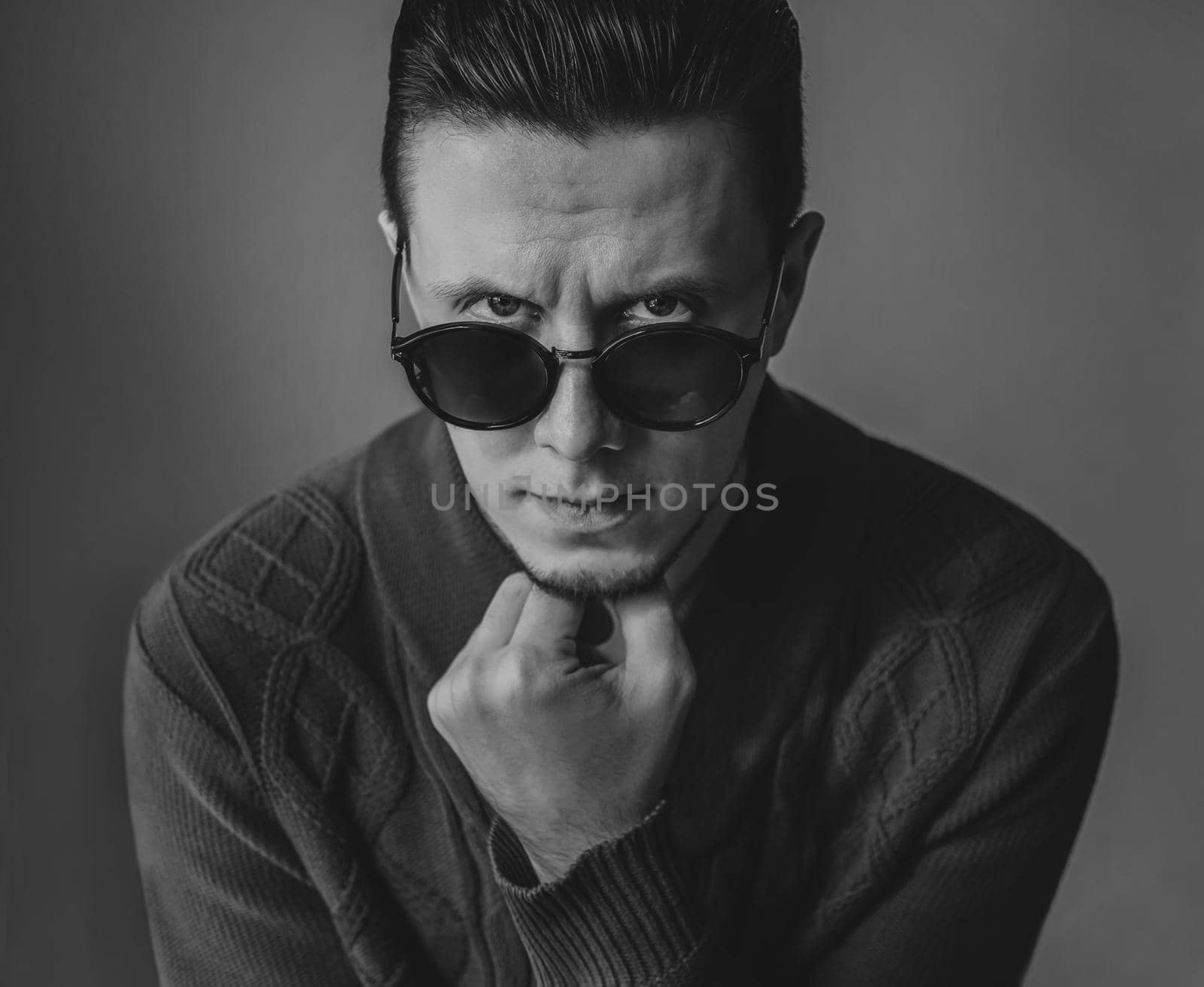 Portrait of handsome fashionable brunet man in sunglasses. Black and white image