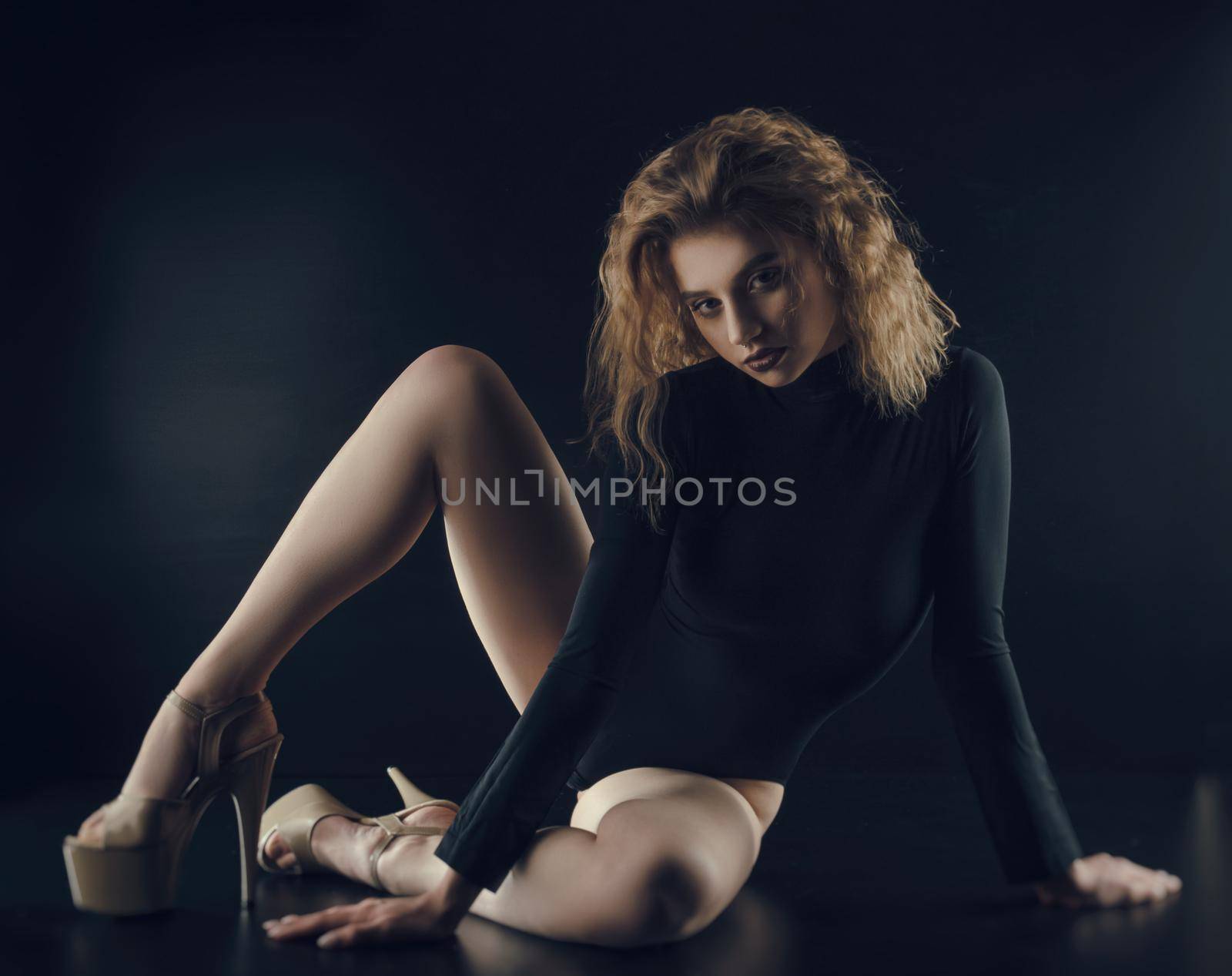 flexible sexy girl poses on a black background in the fitting clothes baud by Rotozey