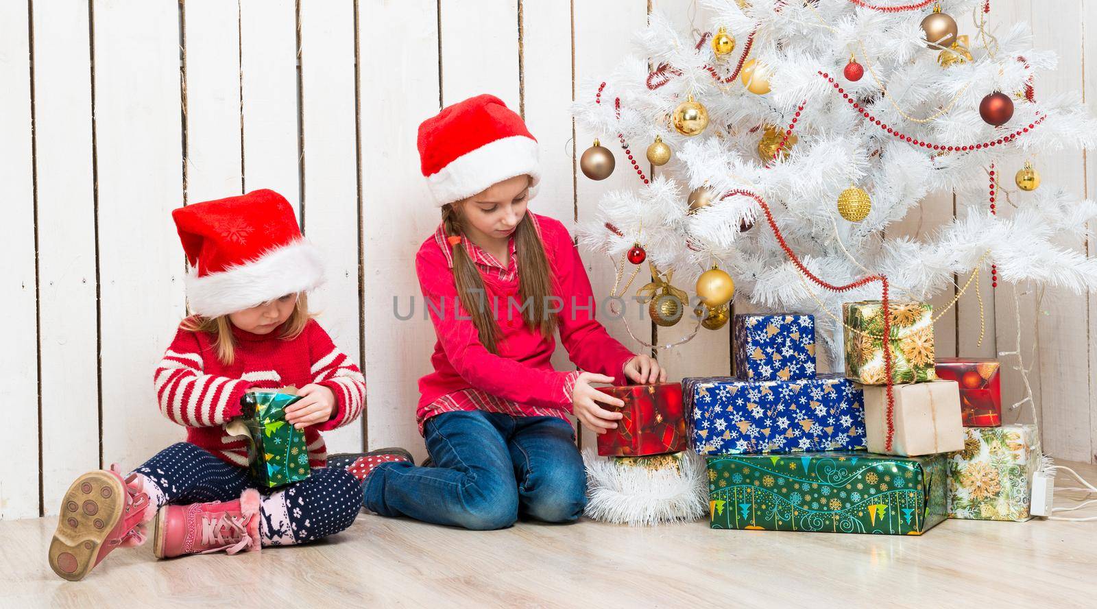two little girls open christmas presents sitting on the floor by GekaSkr