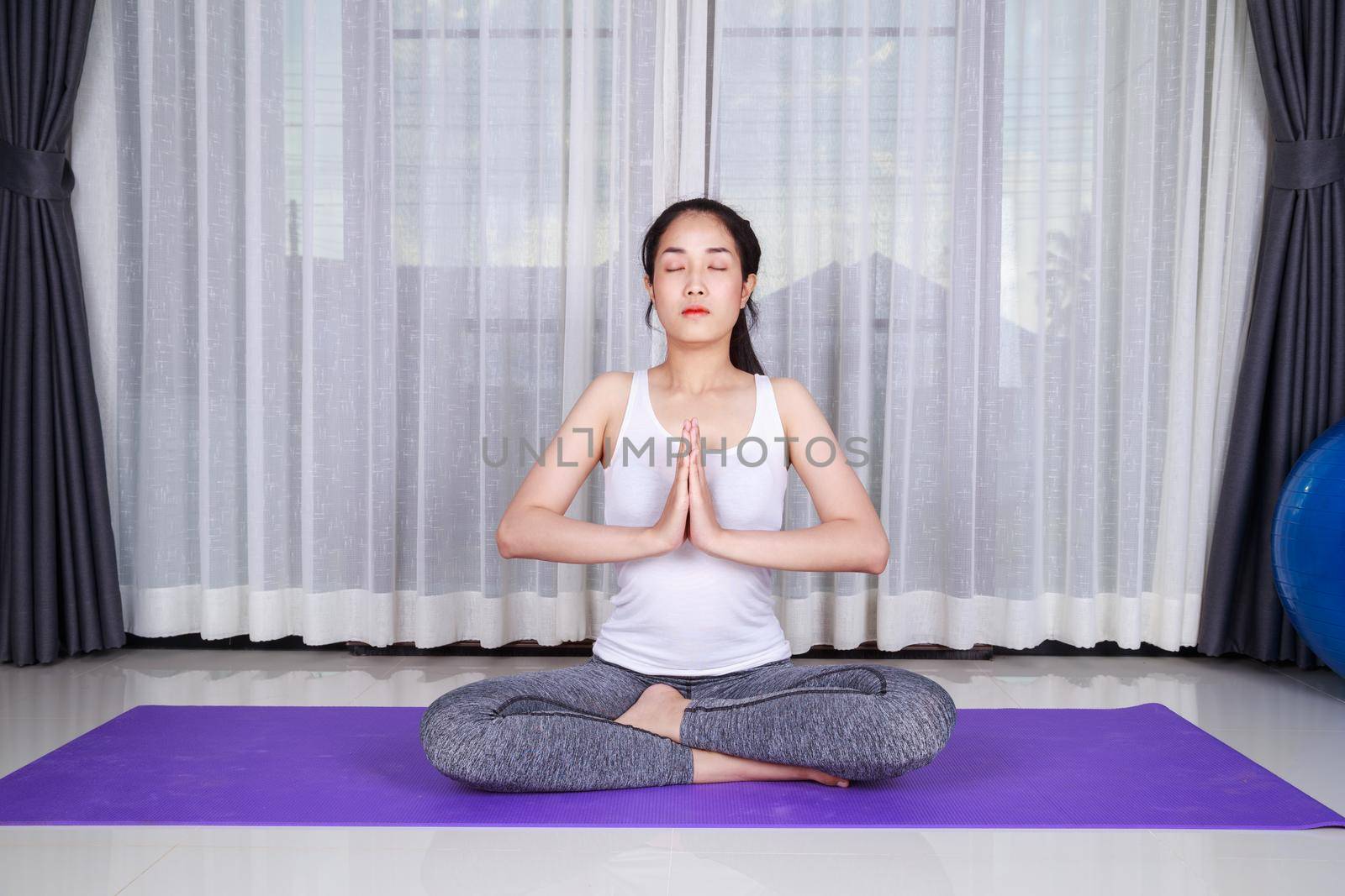 young woman doing yoga exercise isolated on a white background